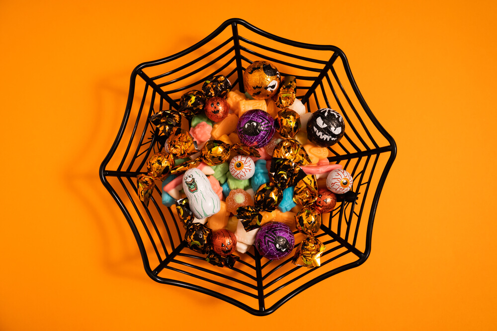 A spiderweb candy bowl to serve guests at a Halloween-themed party.