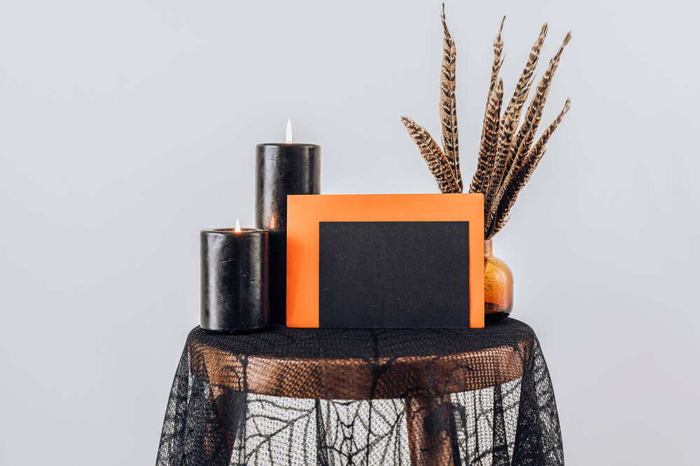 A gift table for a Halloween baby shower decorated in black and orange.