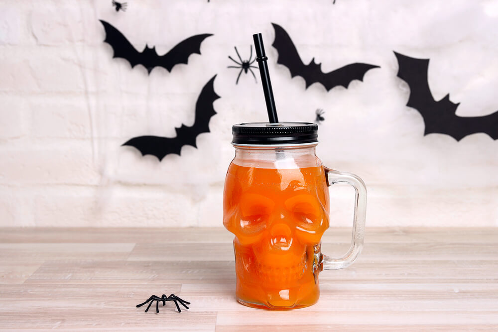 A Halloween party beverage served in a skull-shaped cup.