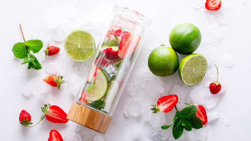 A sustainable water bottle filled with ice and fresh fruit. 
