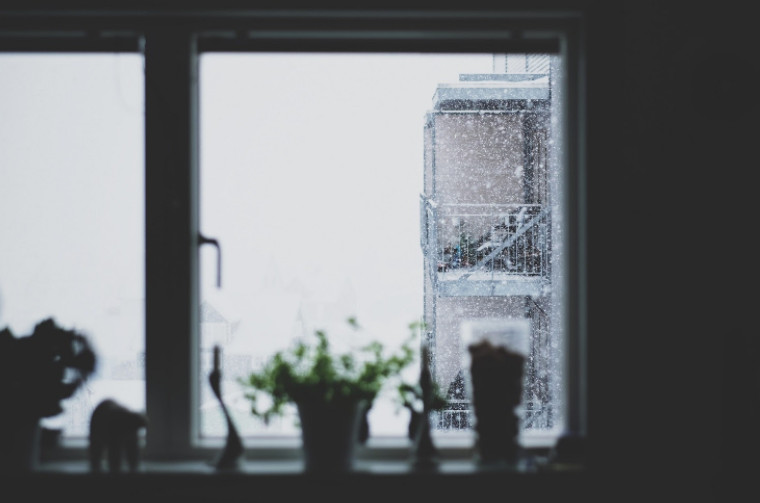 A snowy winter day seen through an apartment window.