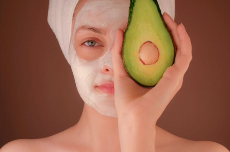 A woman practices self-care with a soothing face mask.