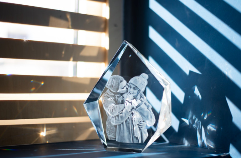 A 3D engraved crystal displays a photo of a loving couple on a winter day.