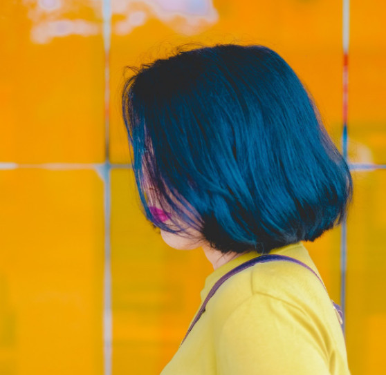 A stylish young woman shows off her freshly dyed blue hair.