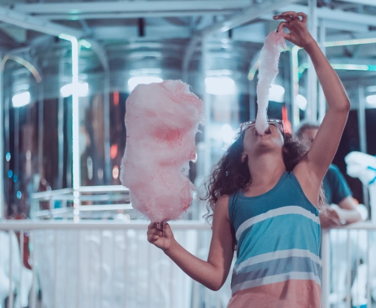 A woman treats herself to some sugary cotton candy.