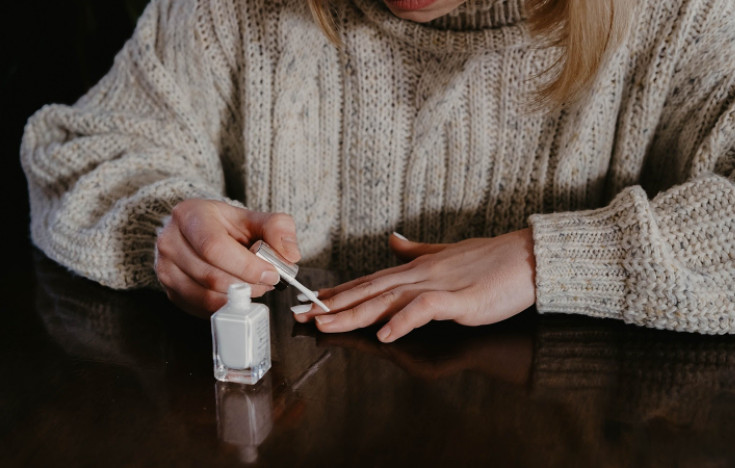 A woman cheers herself up by applying some pretty nail polish.