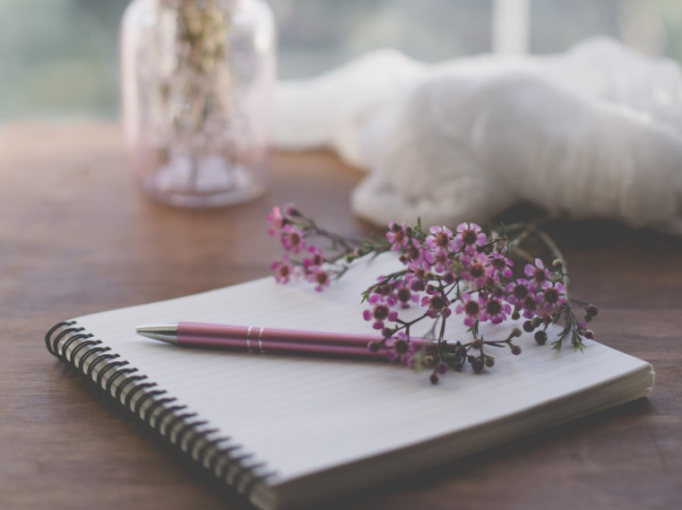 A pen and a spiral notebook for writing a kind letter to a friend.