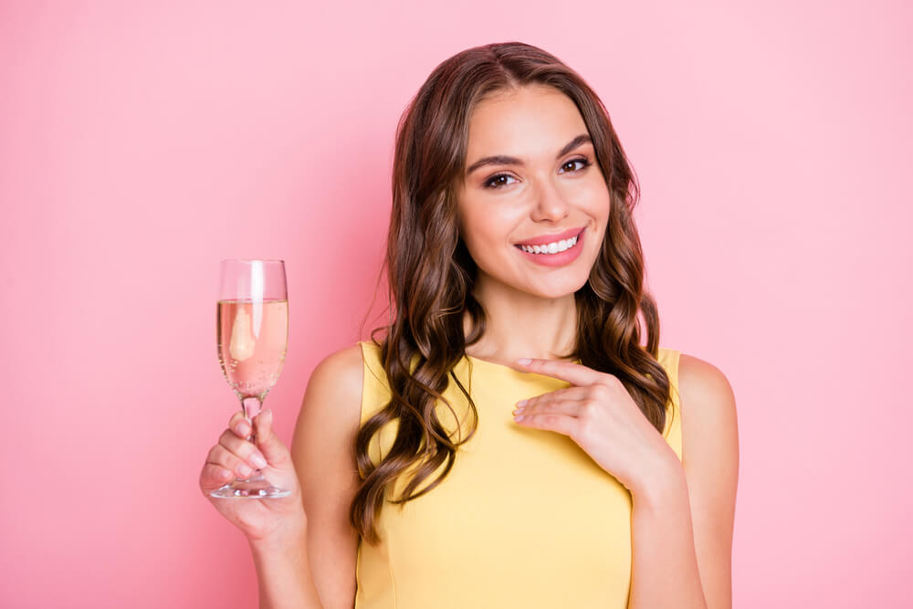 A woman enjoys a glass of champagne on her birthday.