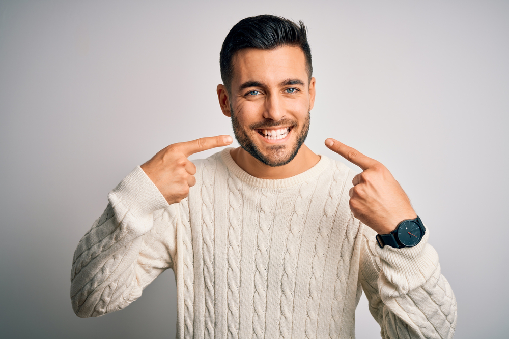 A Libra man shows off his clean, white teeth with a wide smile.