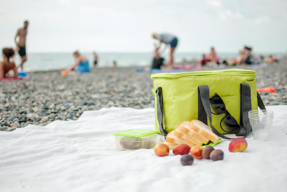 A cooler filled with food for a birthday picnic at the beach.