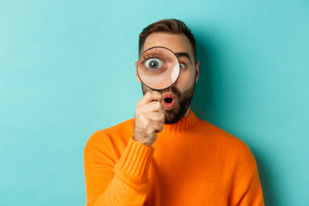 A man is excited to use the magnifying glass he received in his mystery subscription box.