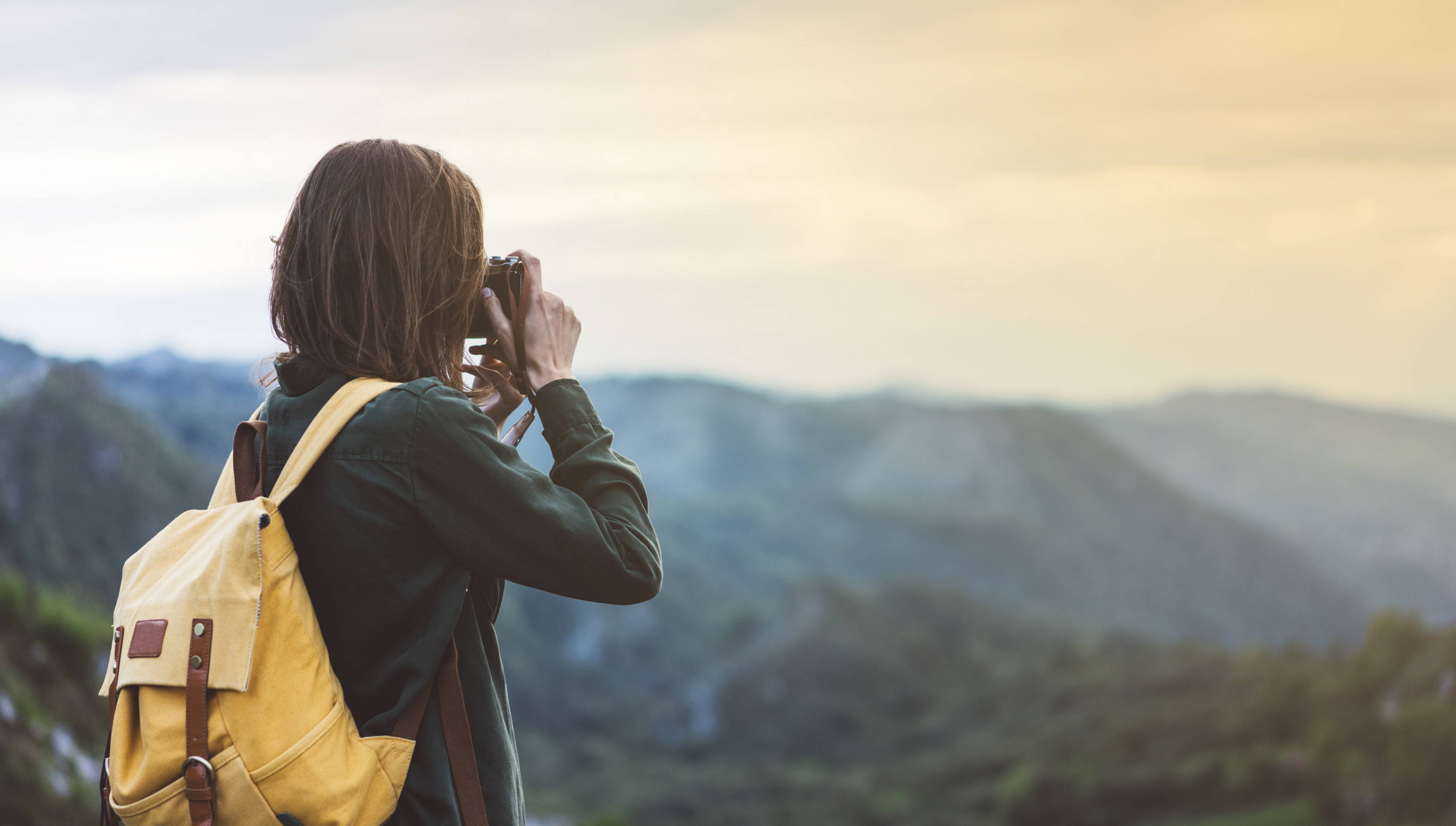 A free-spirited photographer carries camera equipment in her backpack.