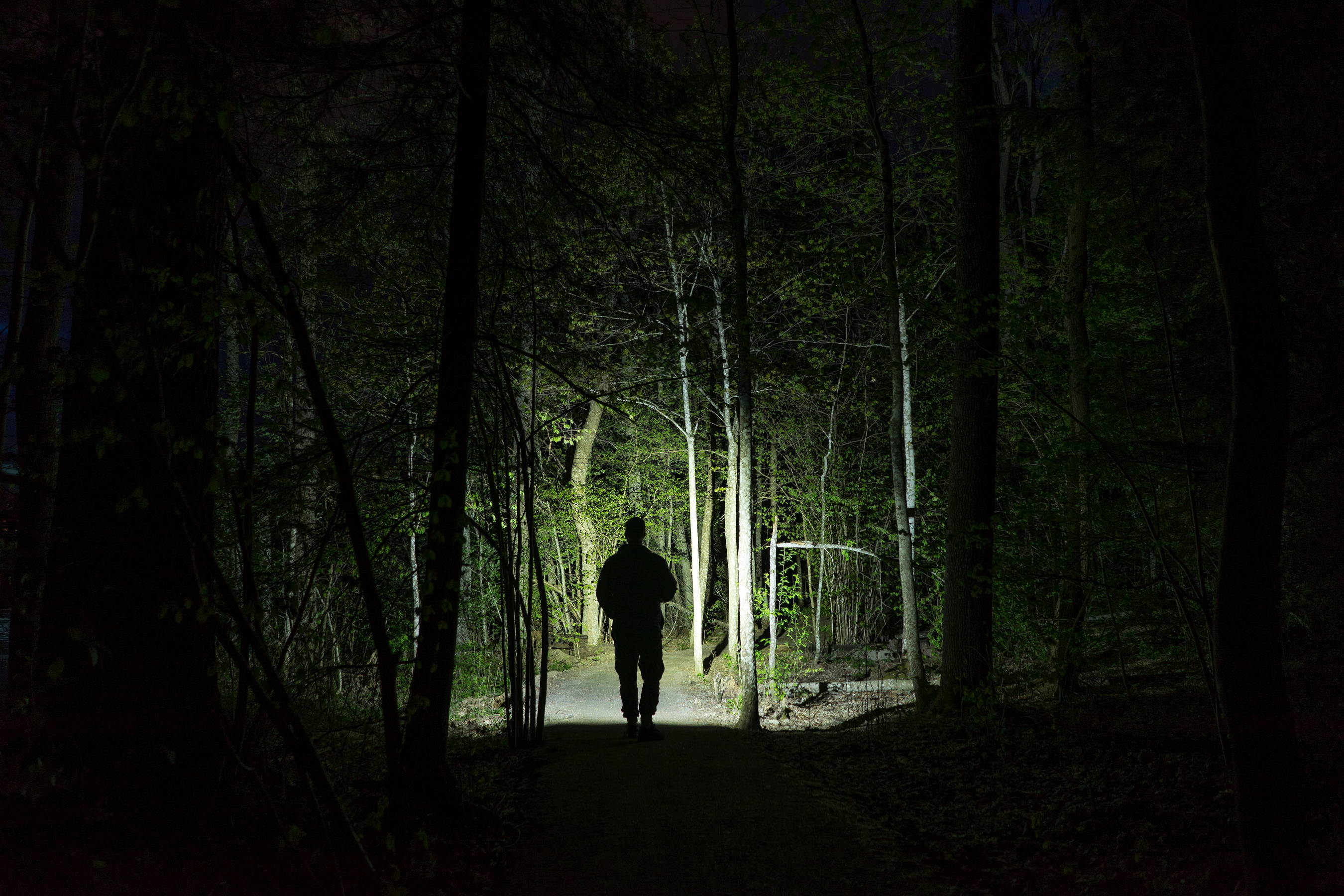 A bold Sagittarius man takes a hike in the dark with night vision goggles.