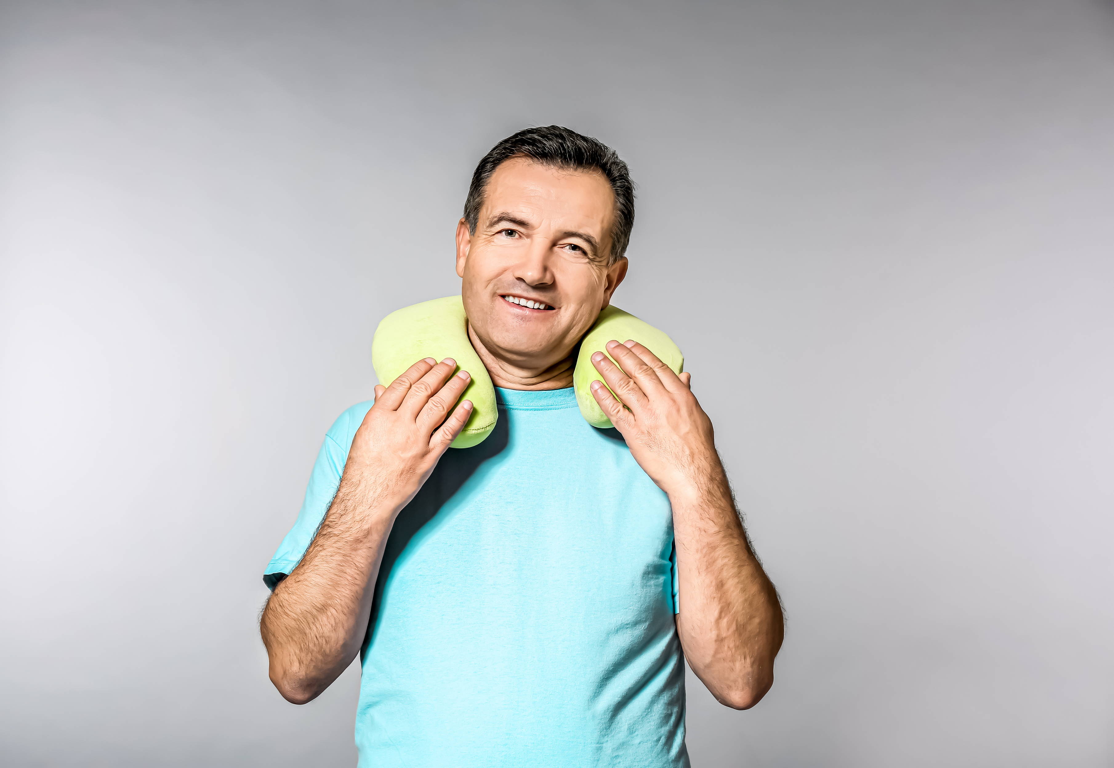 A man wears the neck pillow he received as a Secret Santa gift.