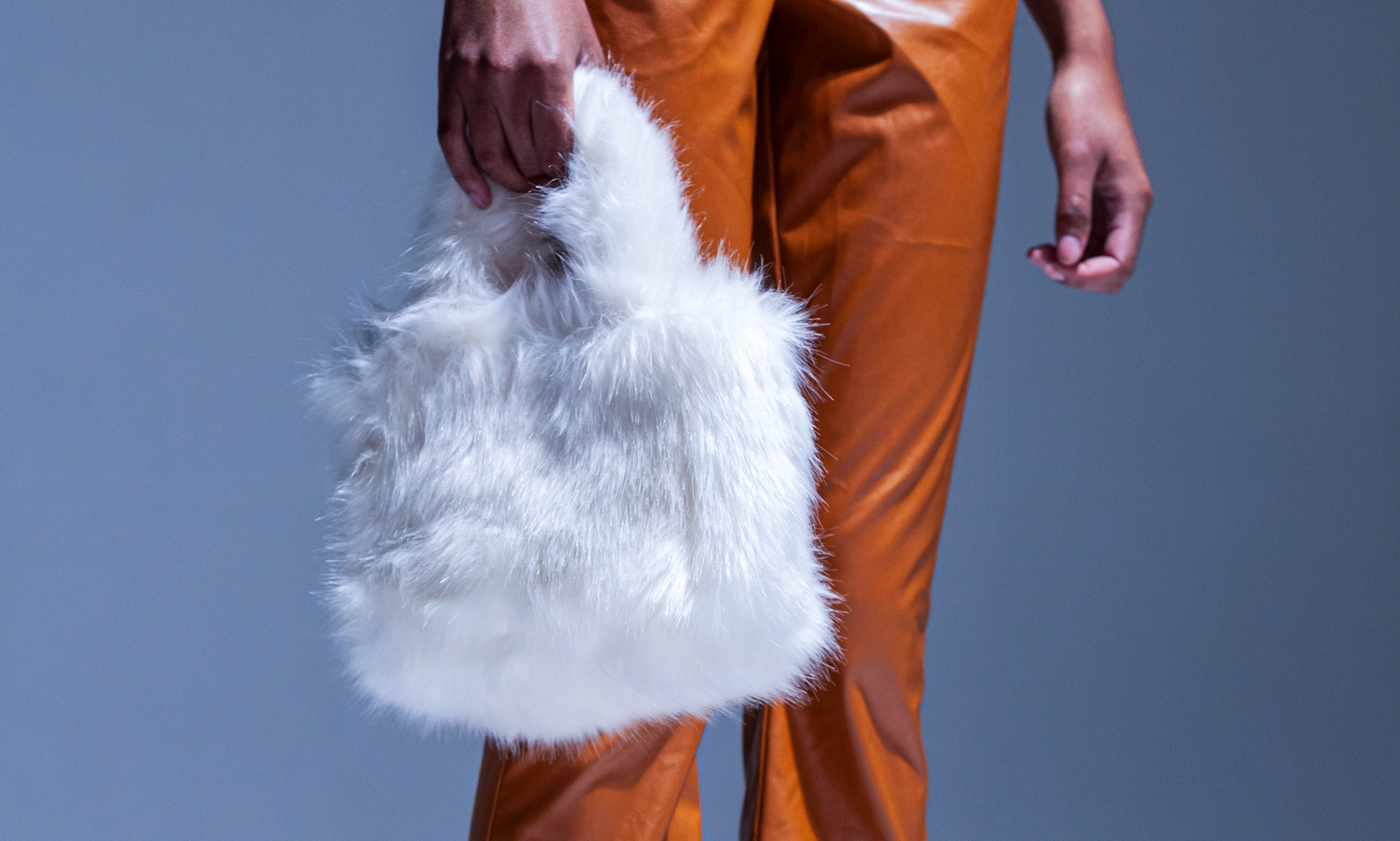 A woman carries a trendy faux fur purse for winter.