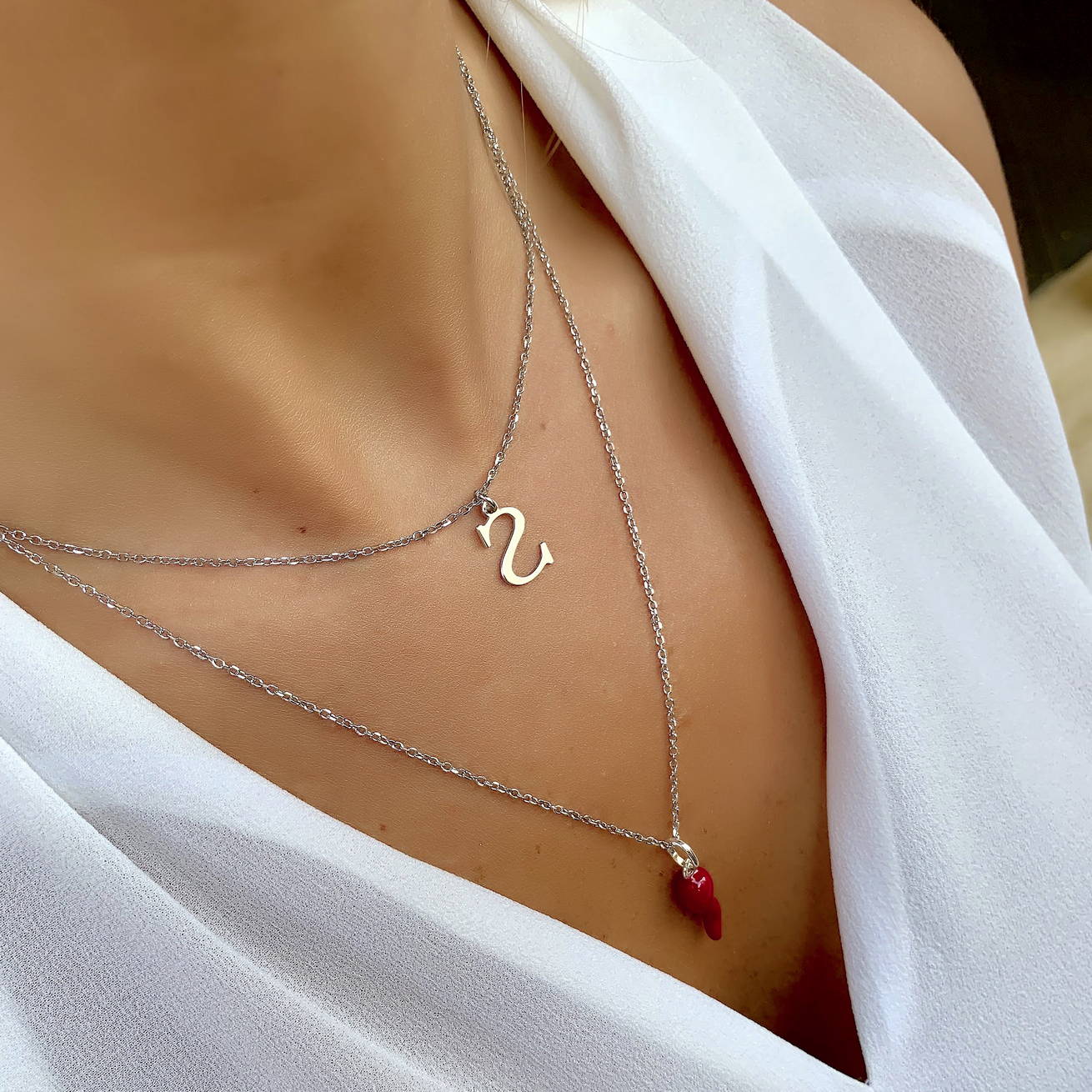 A woman wears a necklace with her initial on it that she got for Christmas.