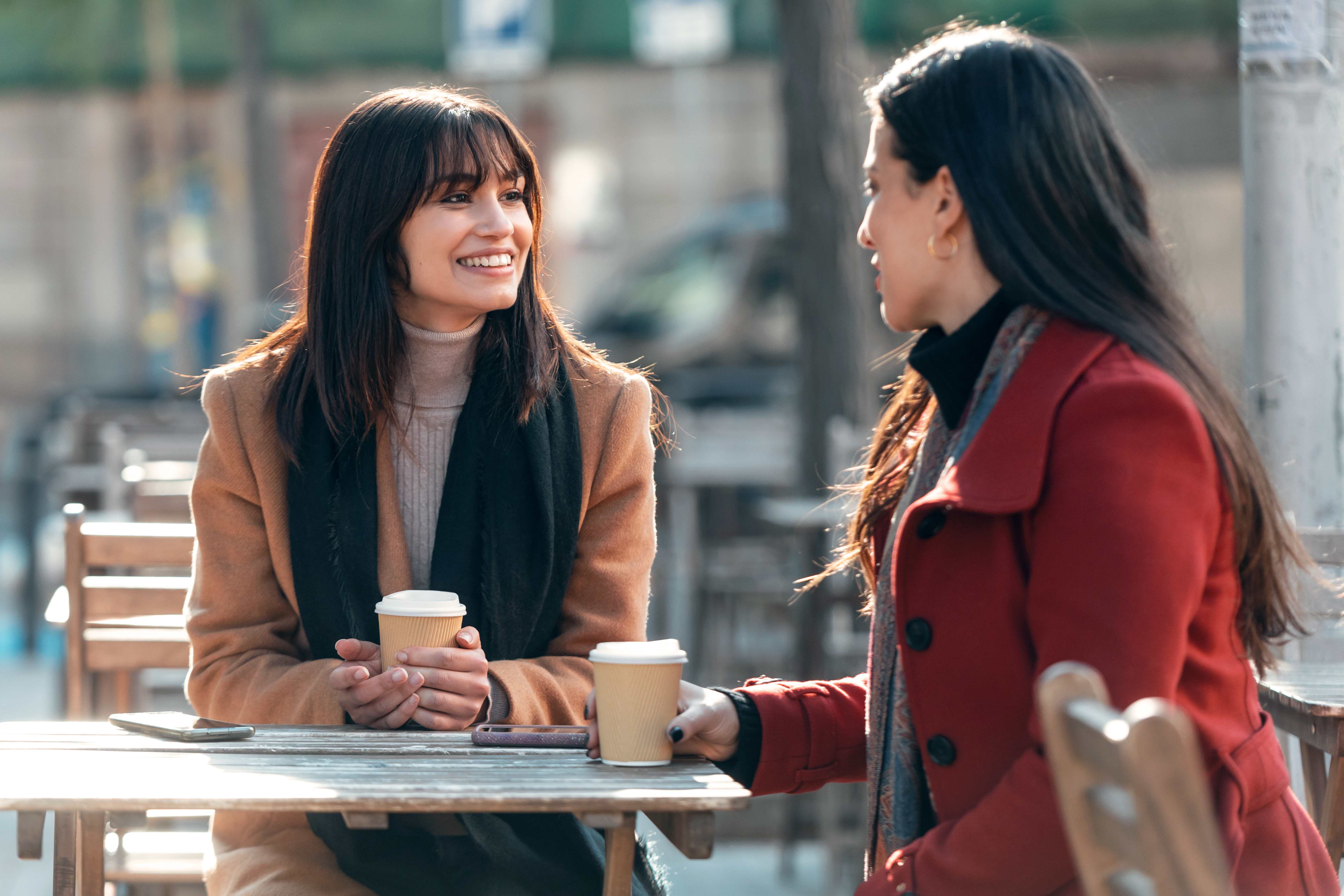 A pair of friends meet for coffee to de-stress from their busy schedules.