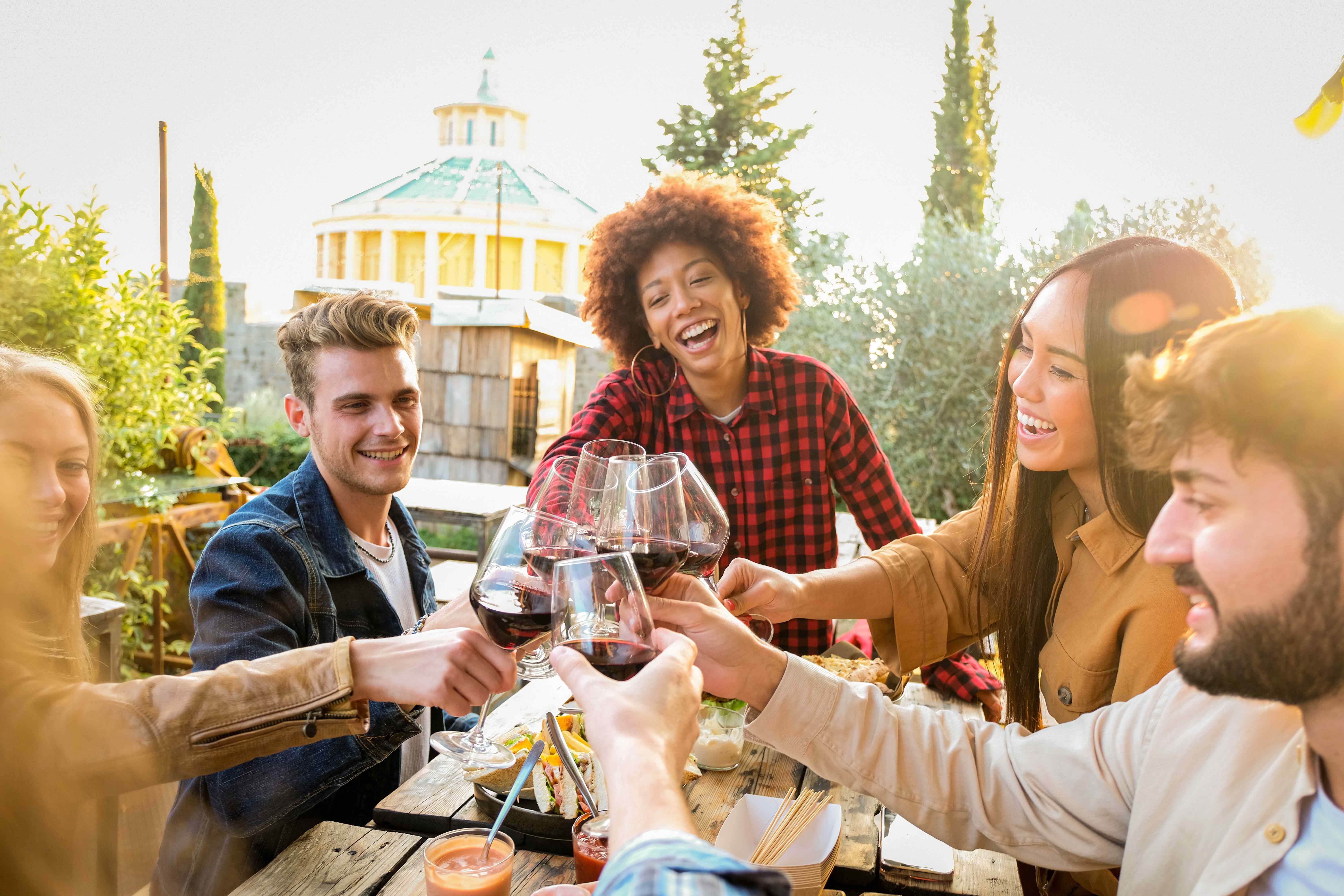 A happy group of adults toast their friend at his birthday dinner party.