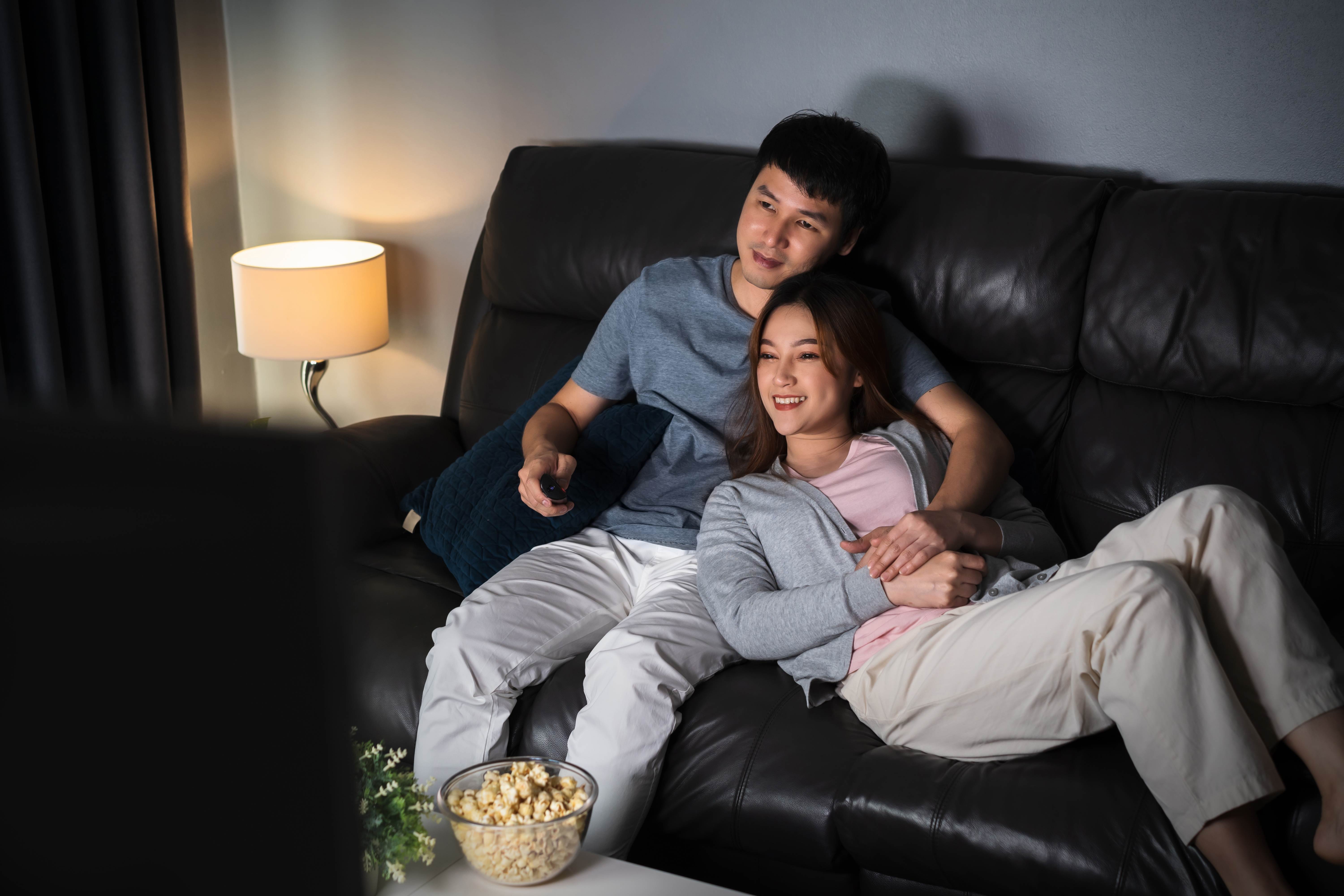 A cute couple enjoys their new sound system together on movie night. 