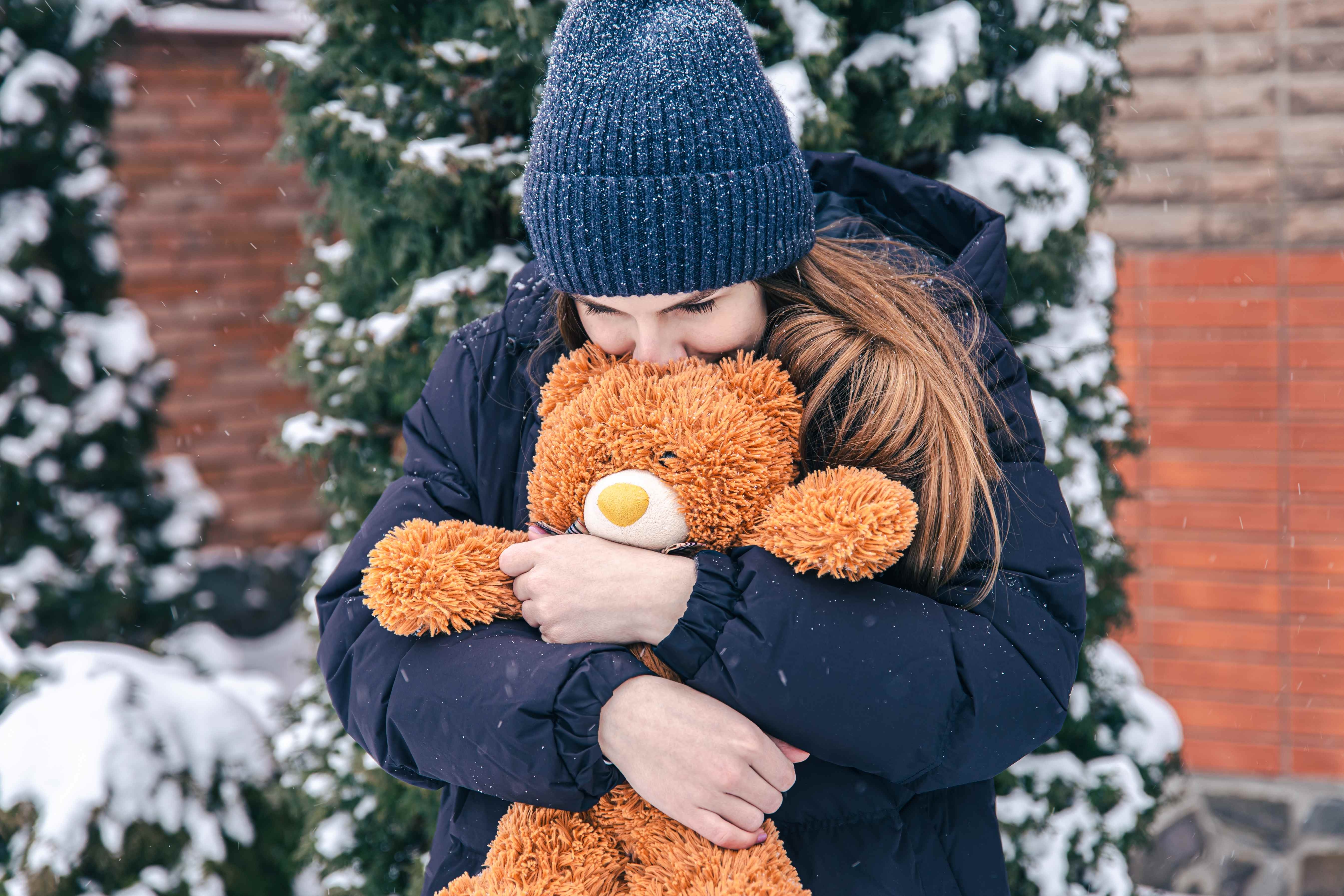 A woman cuddles the sweet teddy bear her boyfriend gave her for Valentine’s Day.