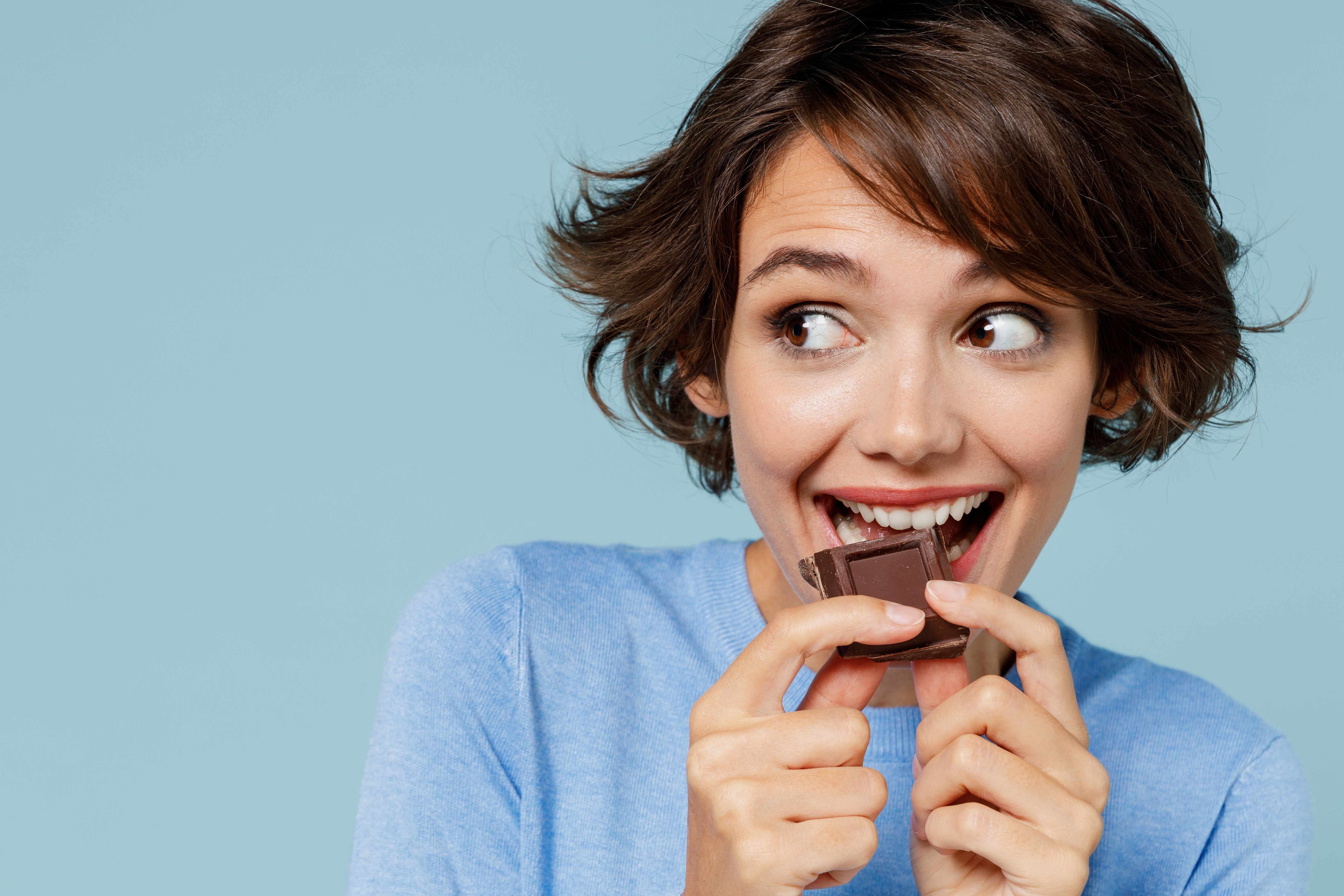 A chocolate-lover treats herself to a piece of candy bar.