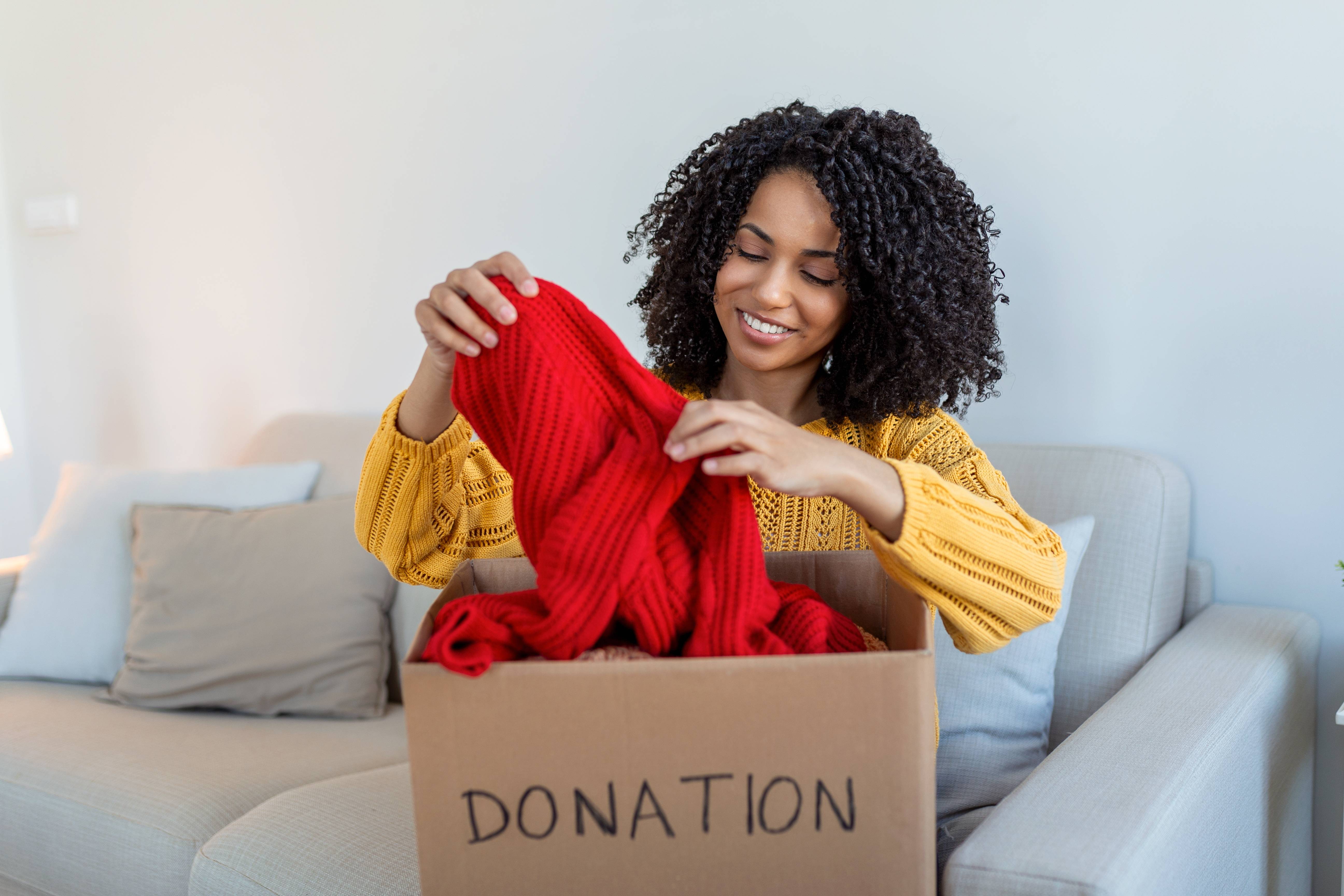 A generous woman donates her red sweater to a local charity.