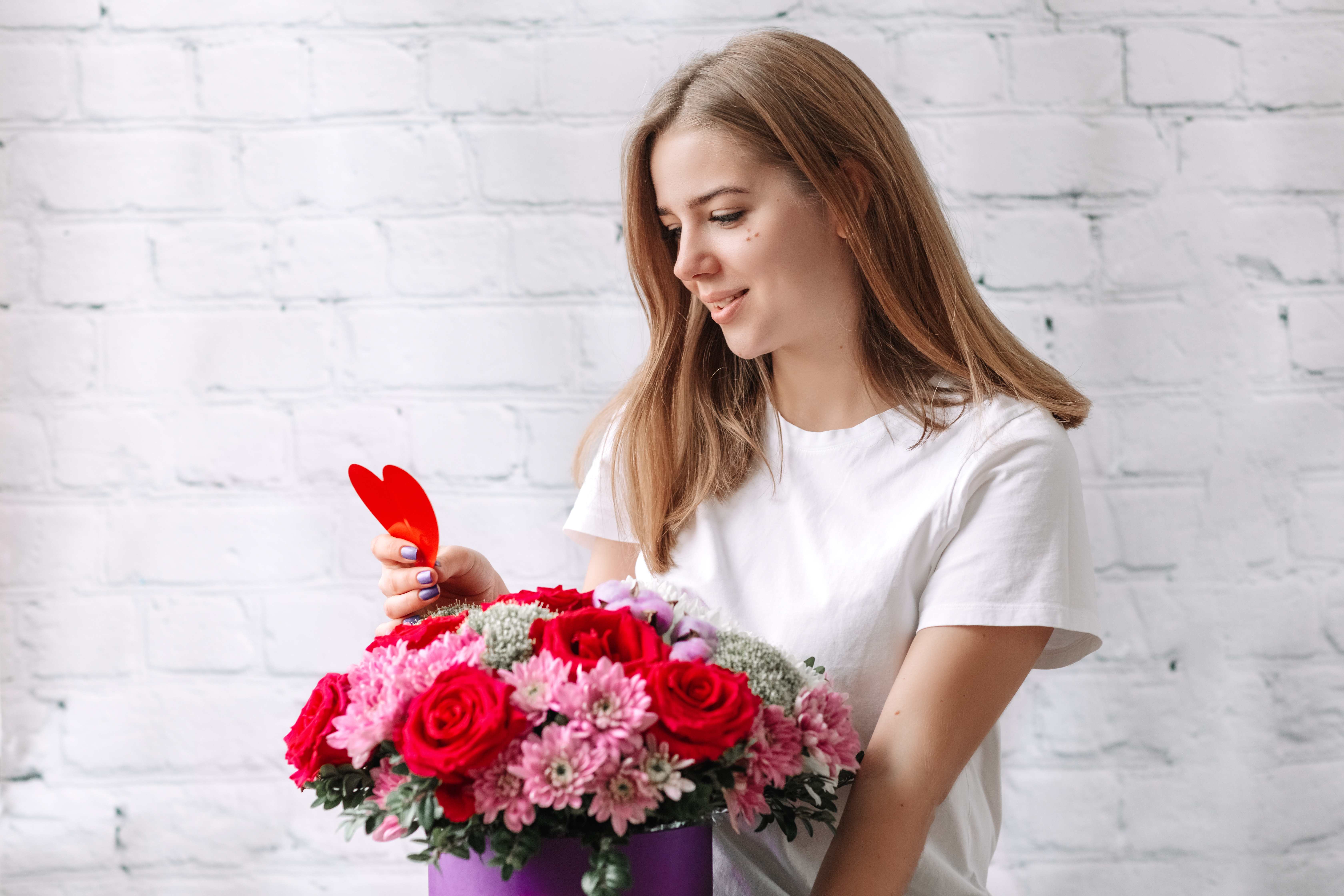 A woman receives a beautiful Valentine’s Day bouquet from her boyfriend. 