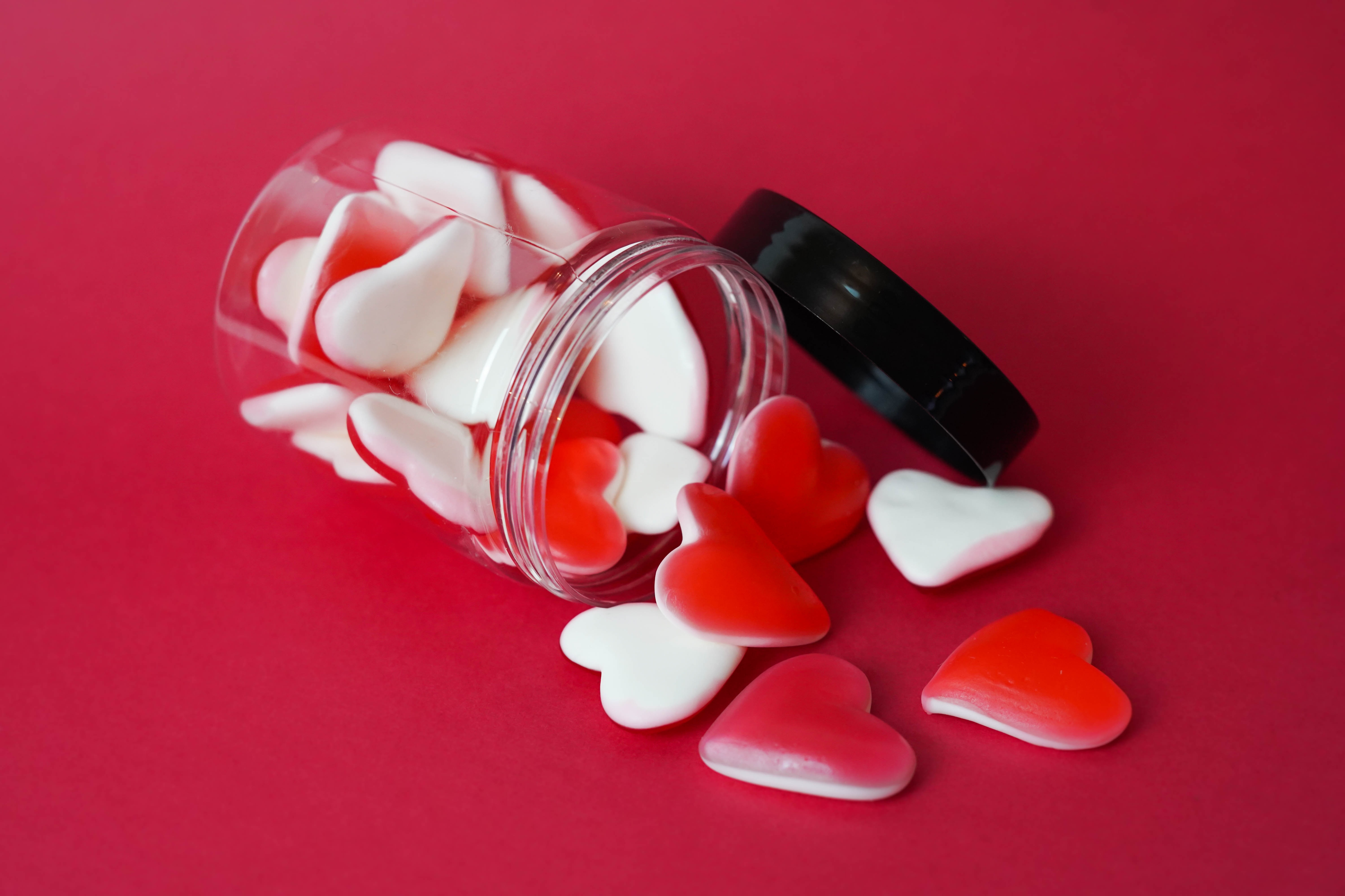 An open container of heart-shaped gummy candies for Valentine’s Day. 