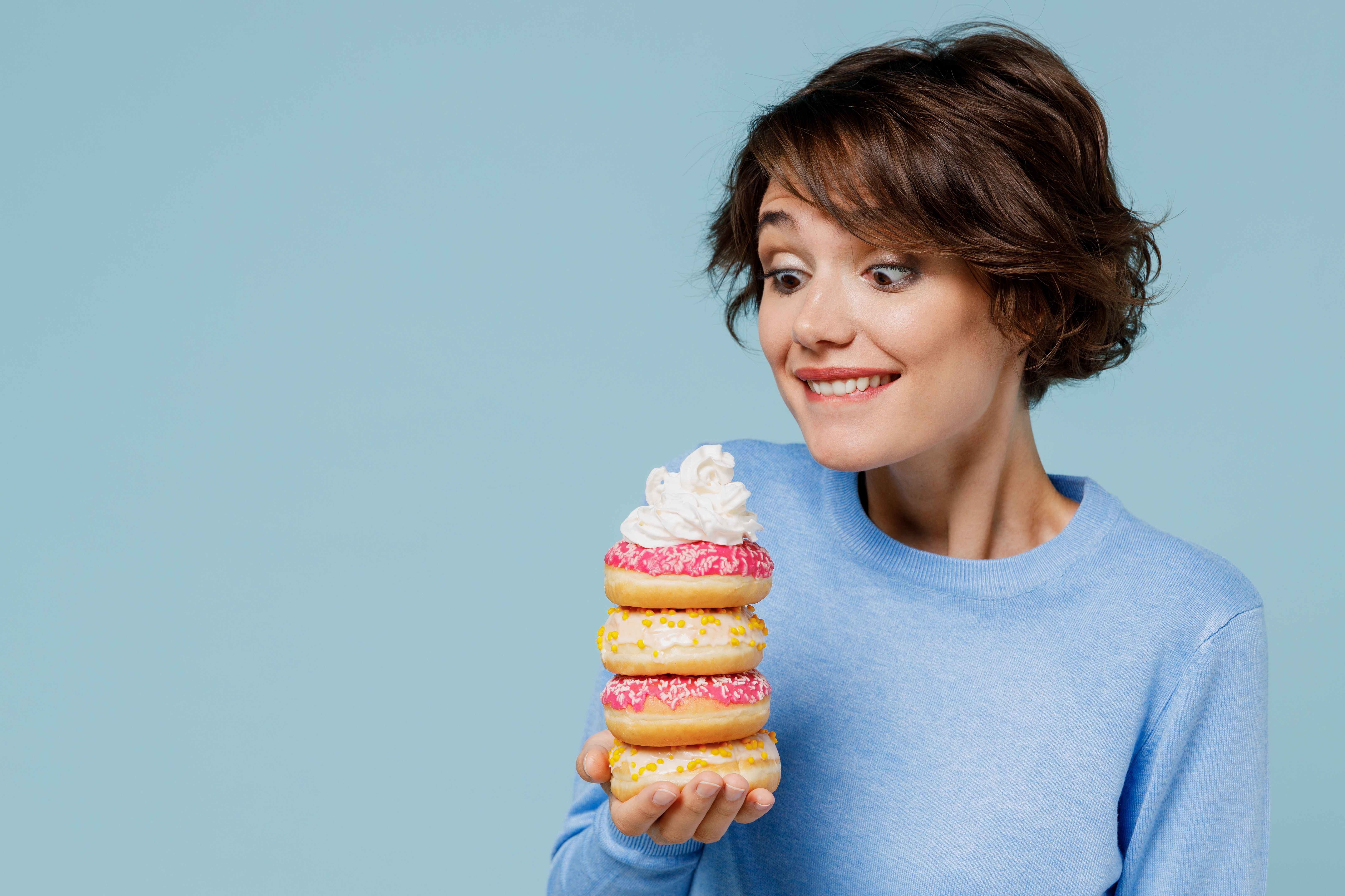 A woman is excited to eat the donuts she received for her birthday.