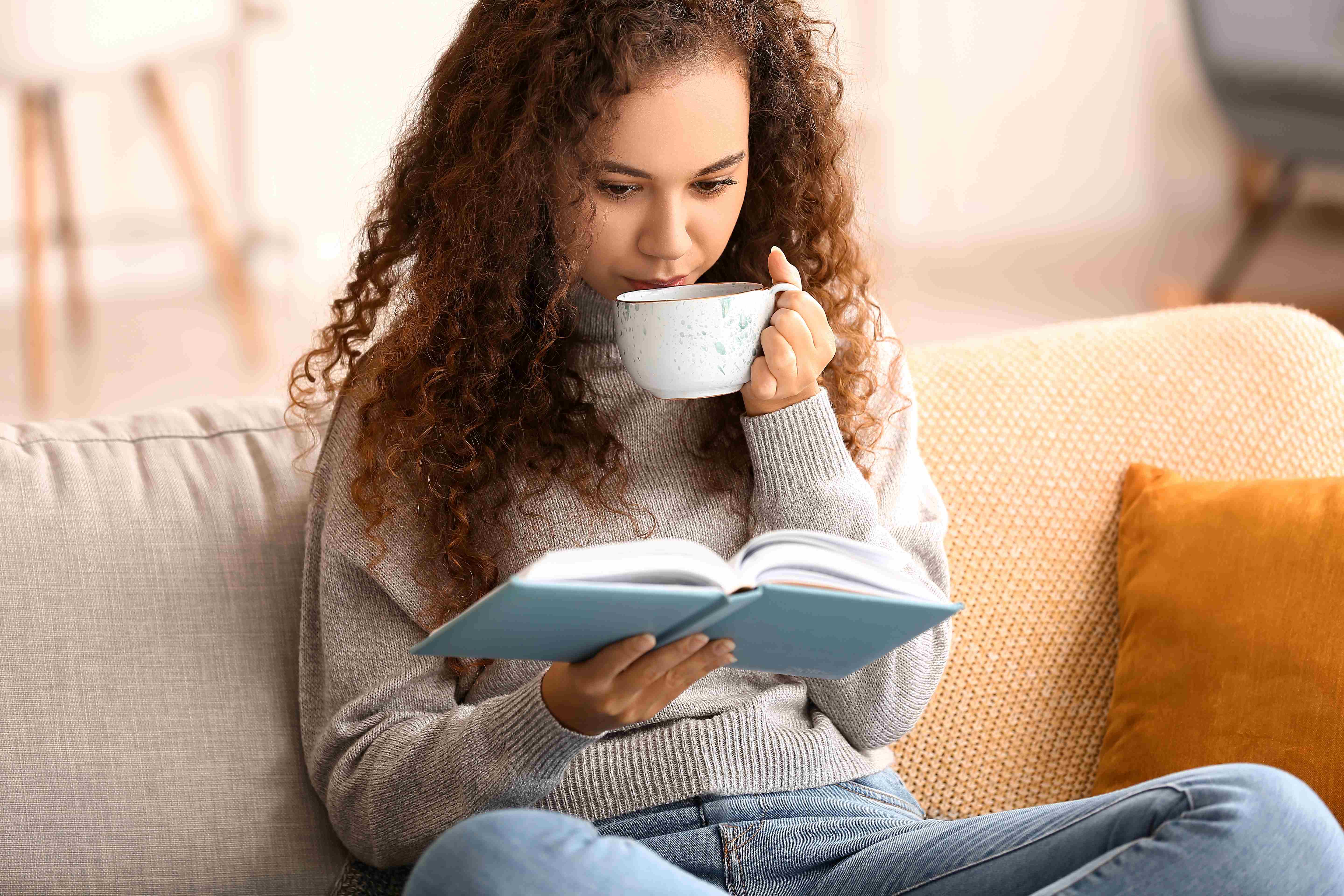 A woman reads a self-help book to achieve personal growth. 