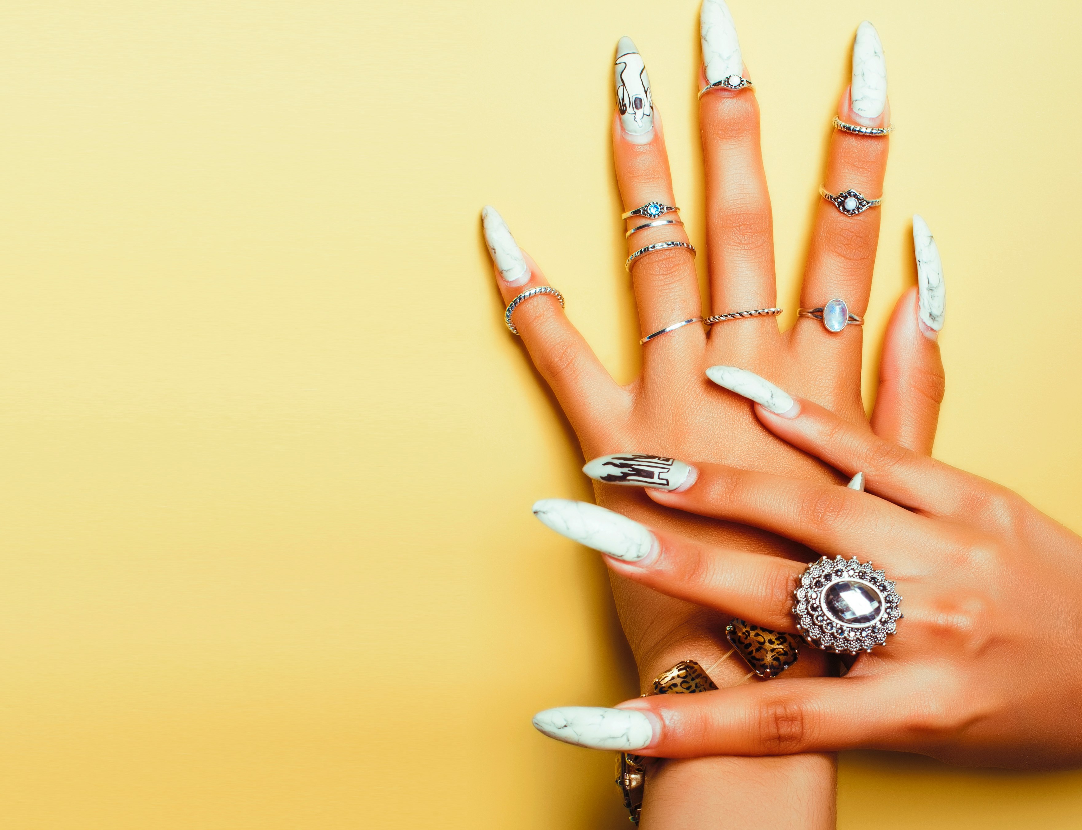 An alternative woman wears a variety of unique rings on her fingers.