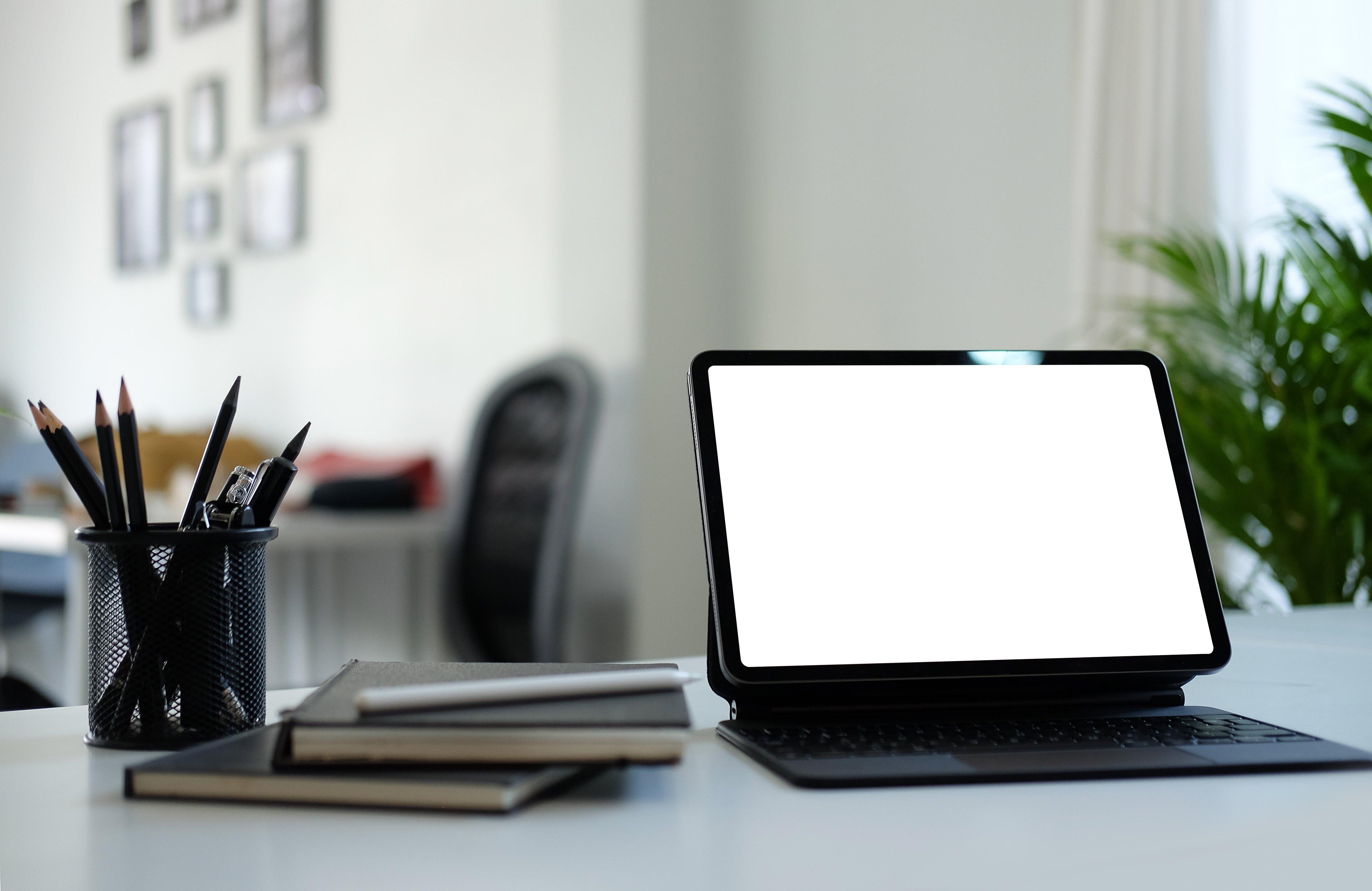 An organized workspace with a tablet on a stand. 