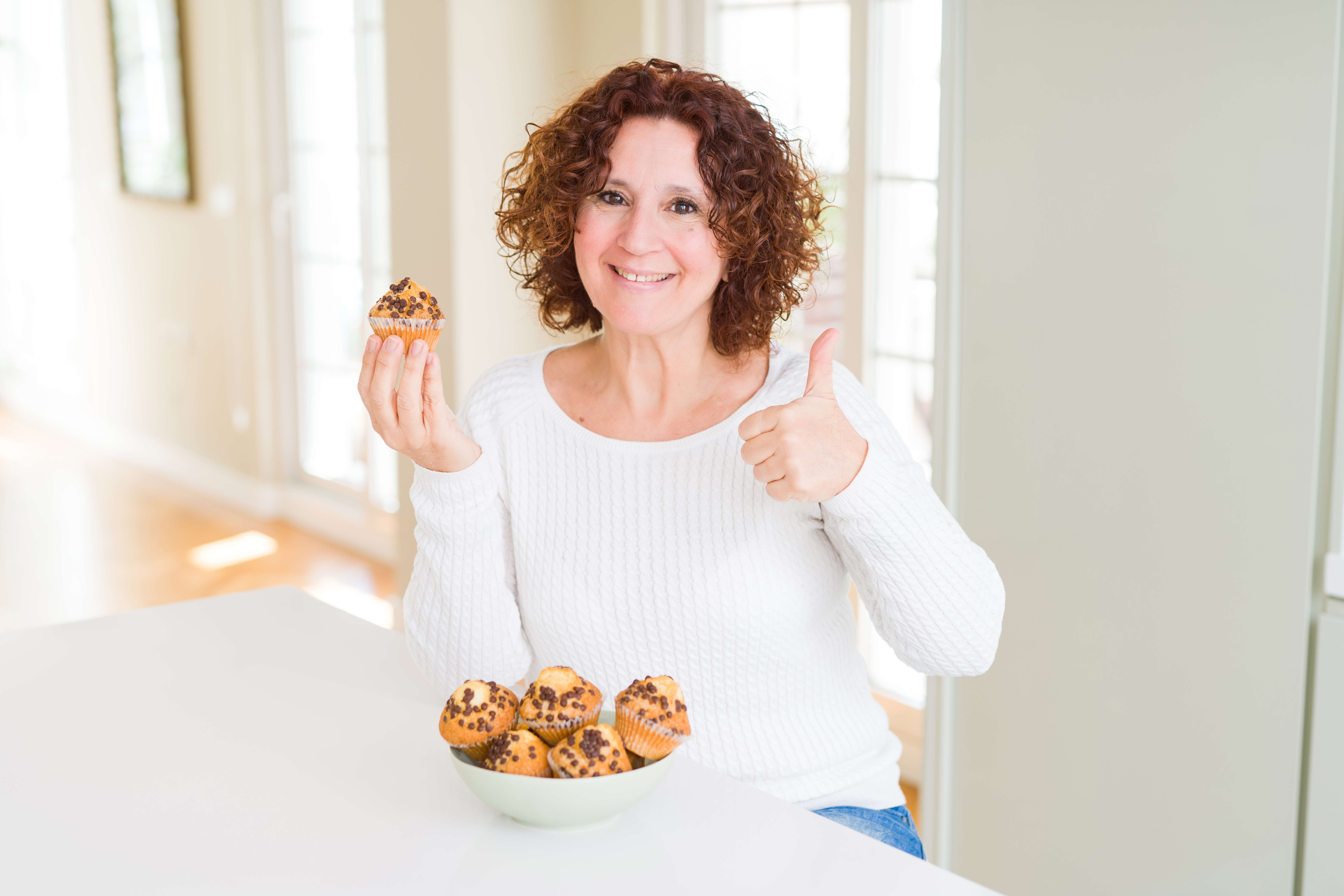 A woman enjoys the muffins she received as a gift from her coworkers.