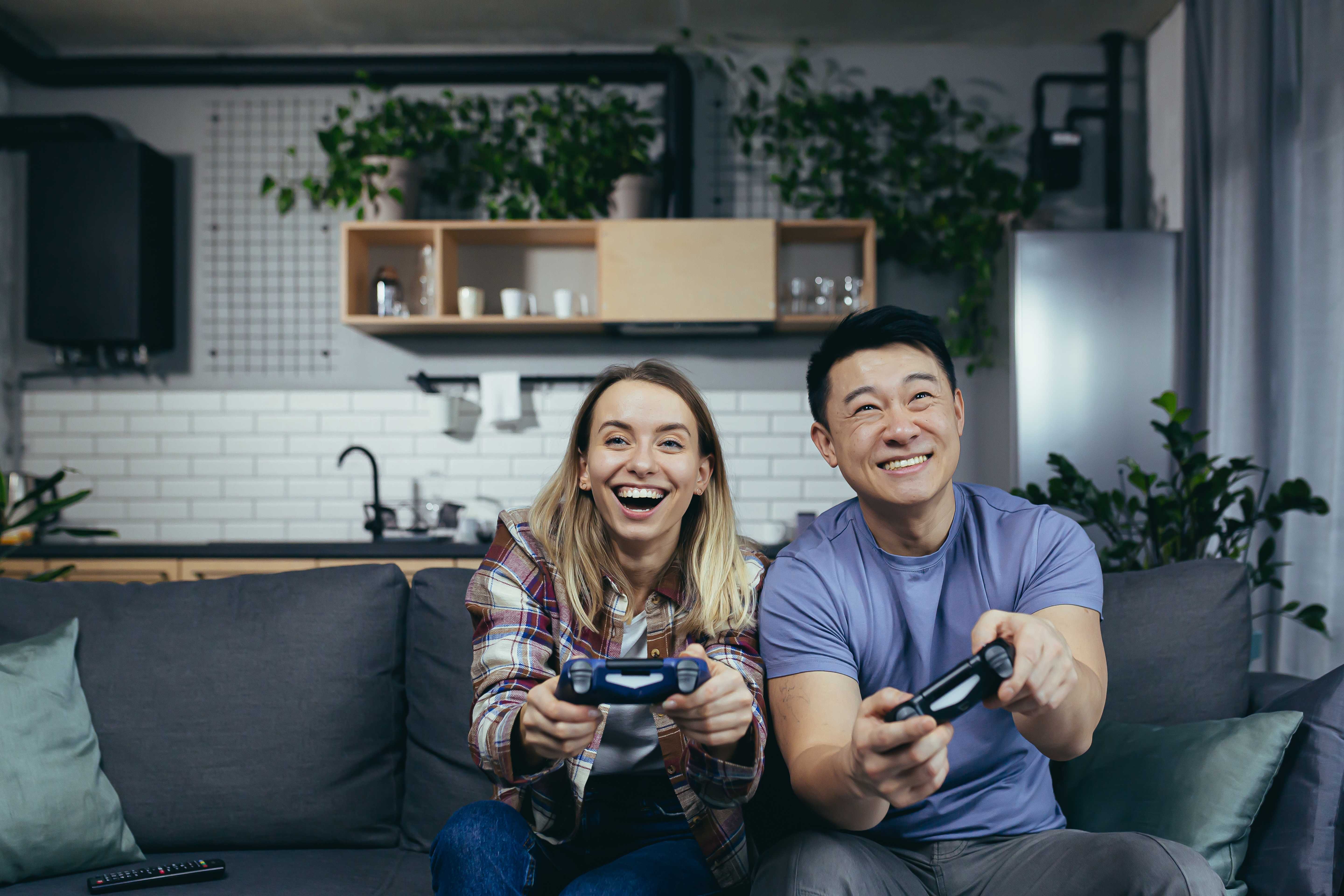 A loving girlfriend plays the video game she bought for her boyfriend’s birthday with him.
