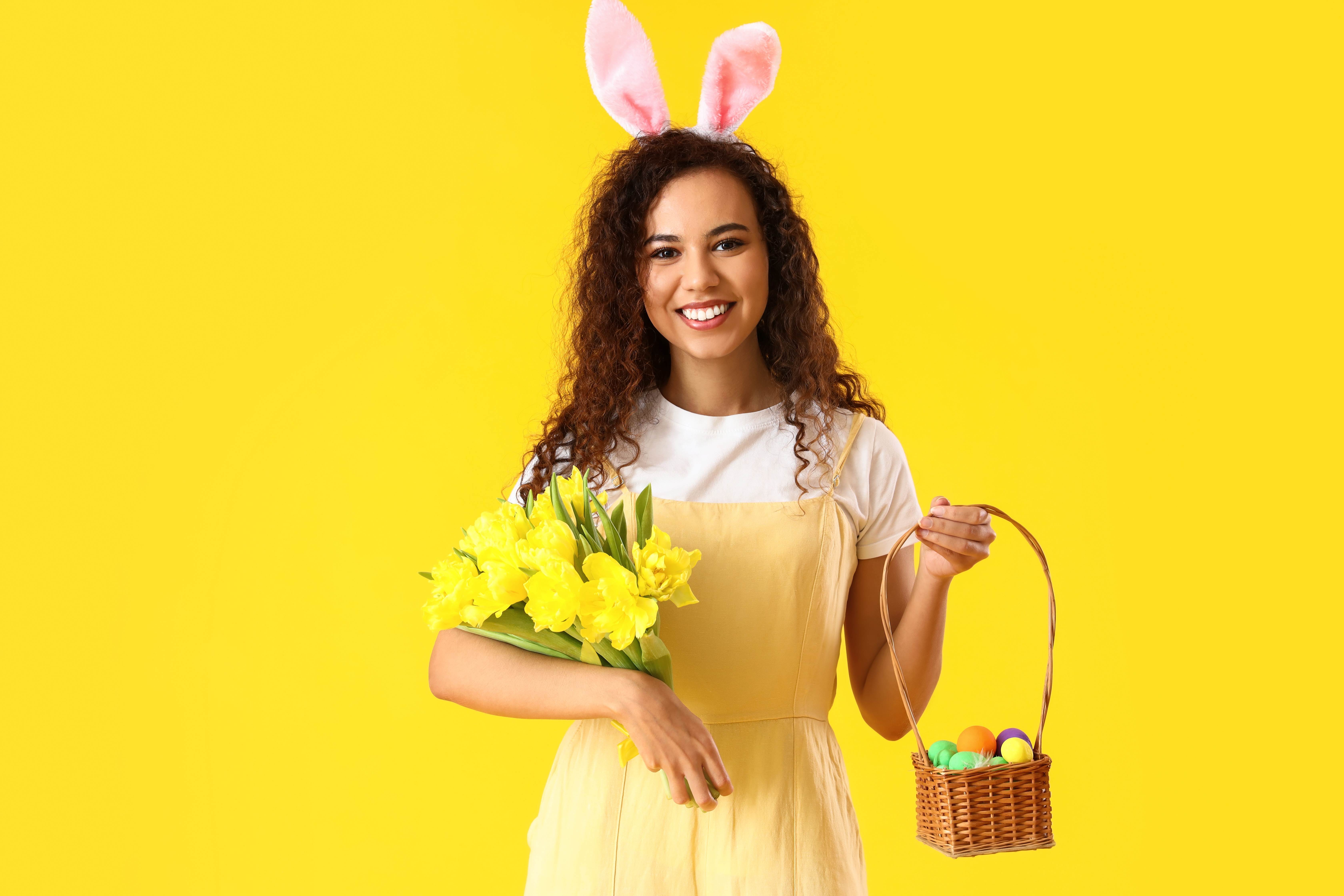 A happy adult woman shows off all the Easter eggs she found.