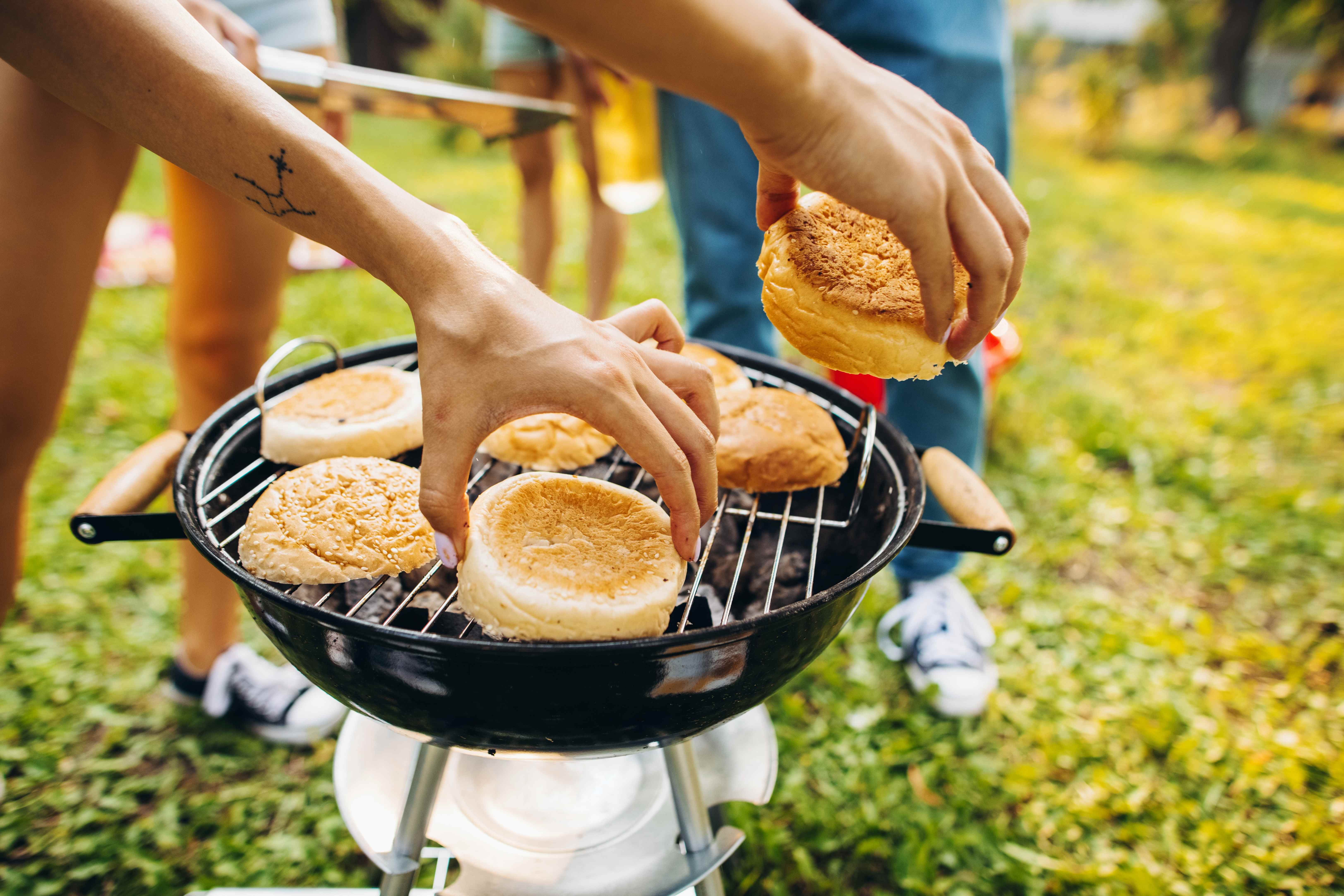 An amateur cook uses a small outdoor grill to make food for friends and family.