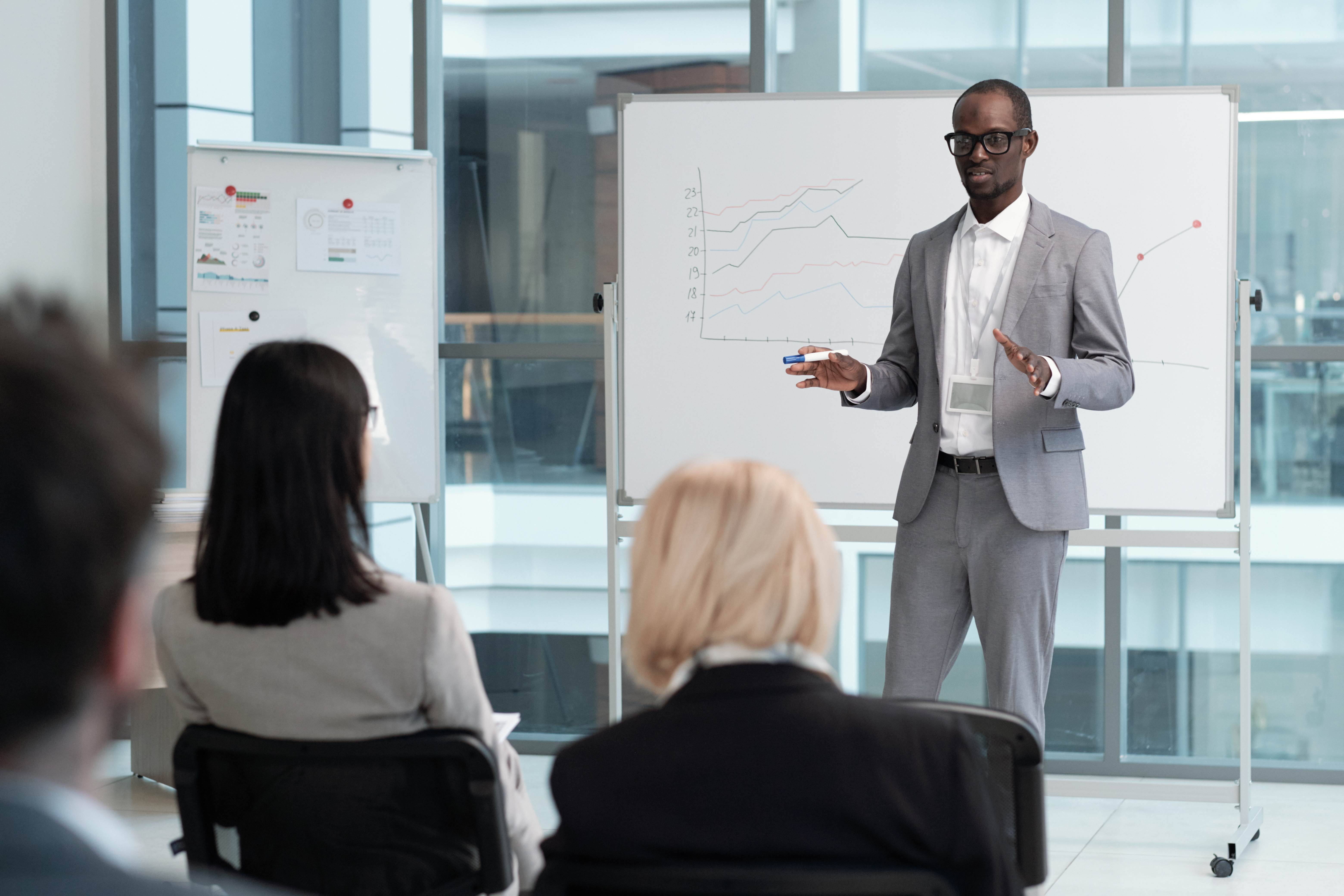 A businessman with strong leadership skills leads a presentation in a comfortable suit.