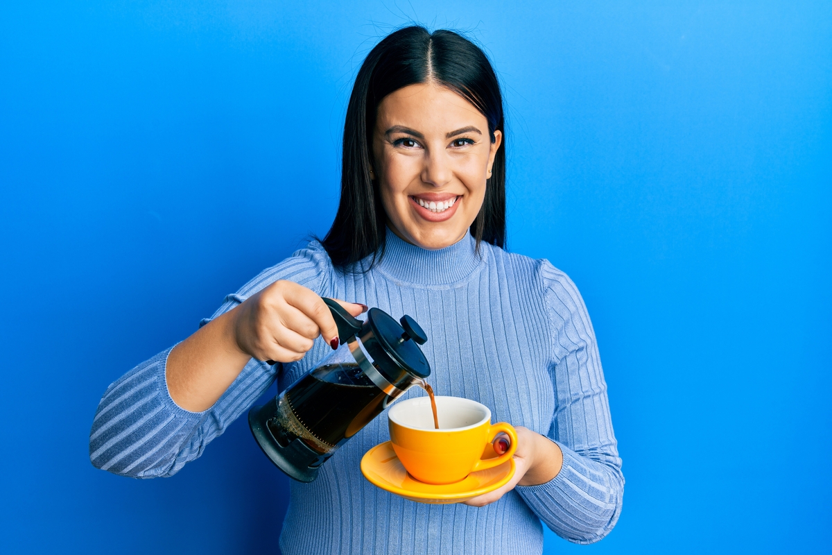 A young mom pours herself a cup of coffee in the morning.