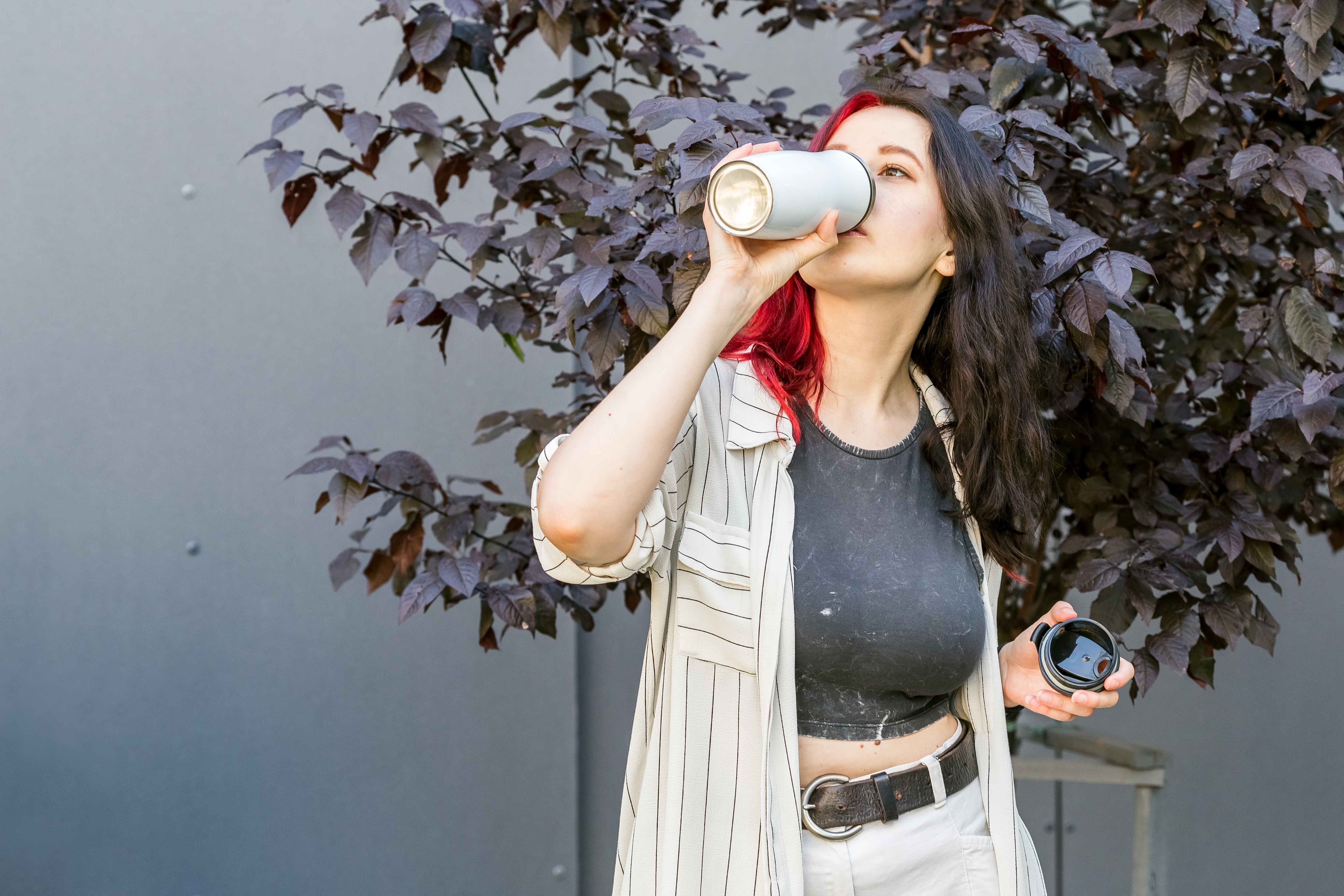 A busy woman uses a travel mug to keep her morning coffee hot.