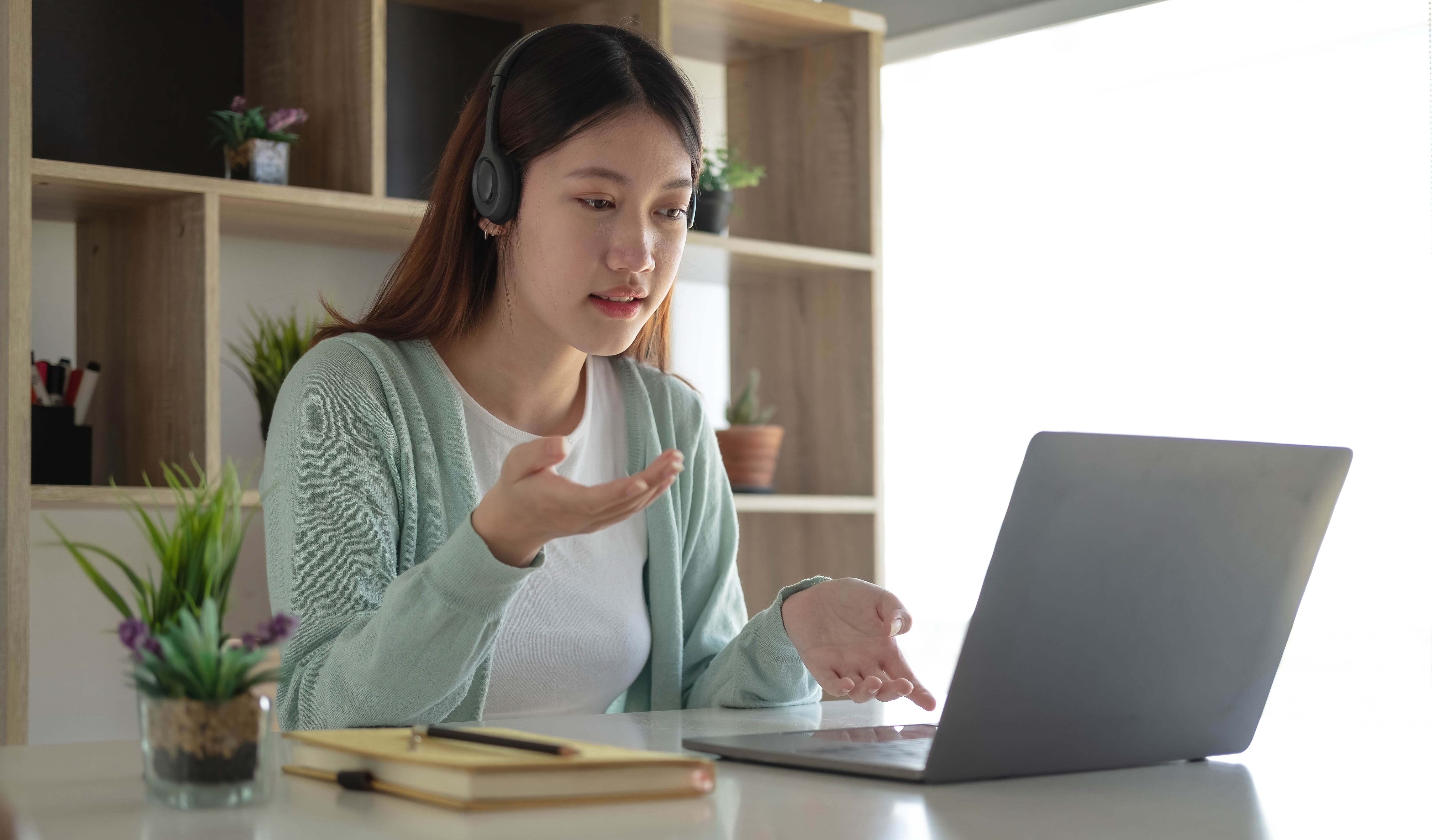 A young woman talks to her therapist over a video call. 