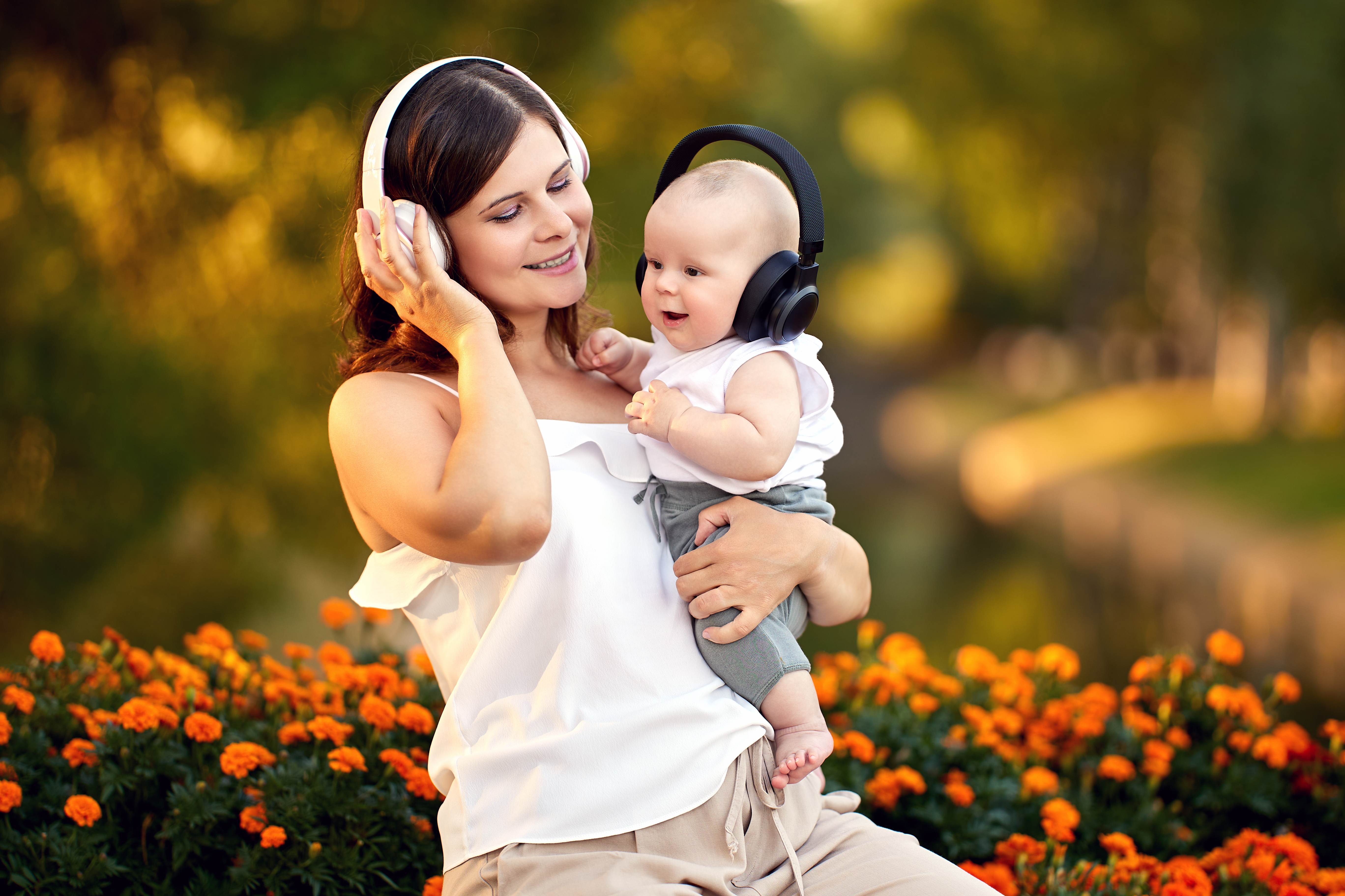 A first-time mother and her baby listen to audiobooks with wireless headphones.