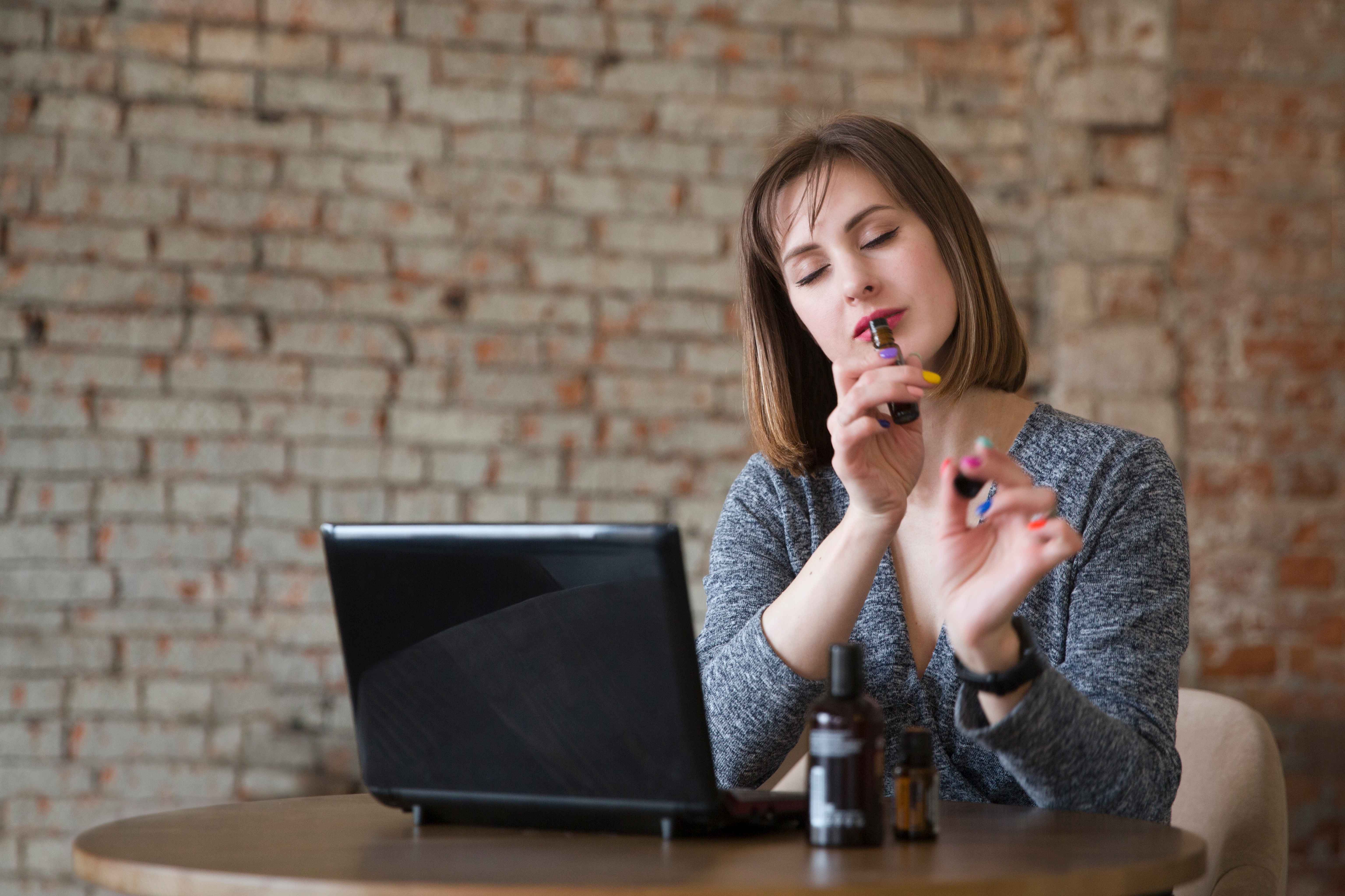 A woman enjoys the scent of her calming essential oils.