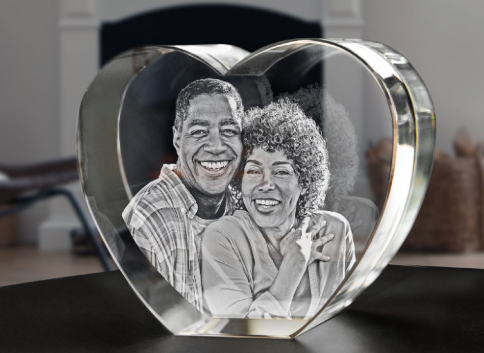 A photo of a loving older couple engraved in 3D inside a heart-shaped crystal.