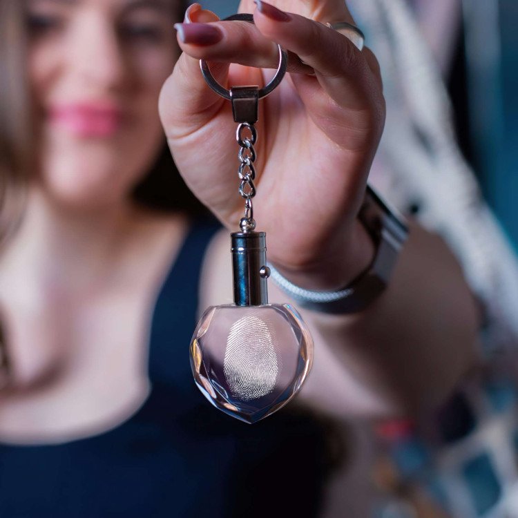 A woman holding up a Fingerprint Heart Keychain with Light