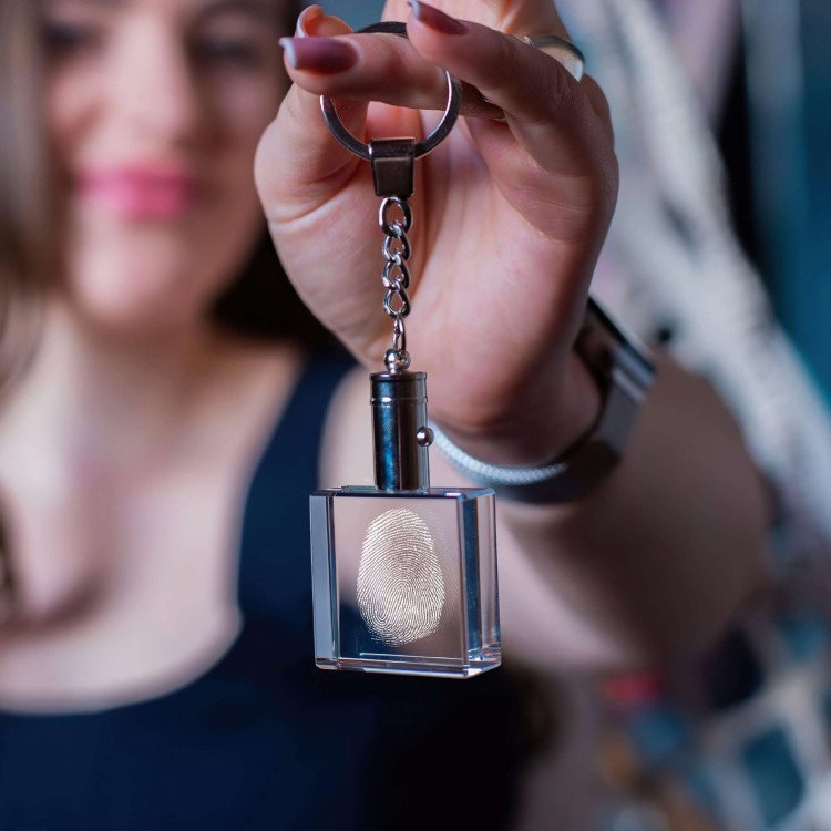 A woman shows off her Fingerprint Square Keychain with built-in LEDs