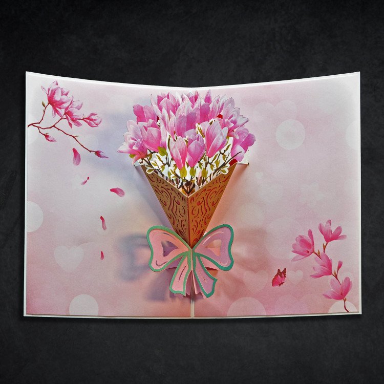 An open greeting card with a pop-up bouquet of pink flowers inside